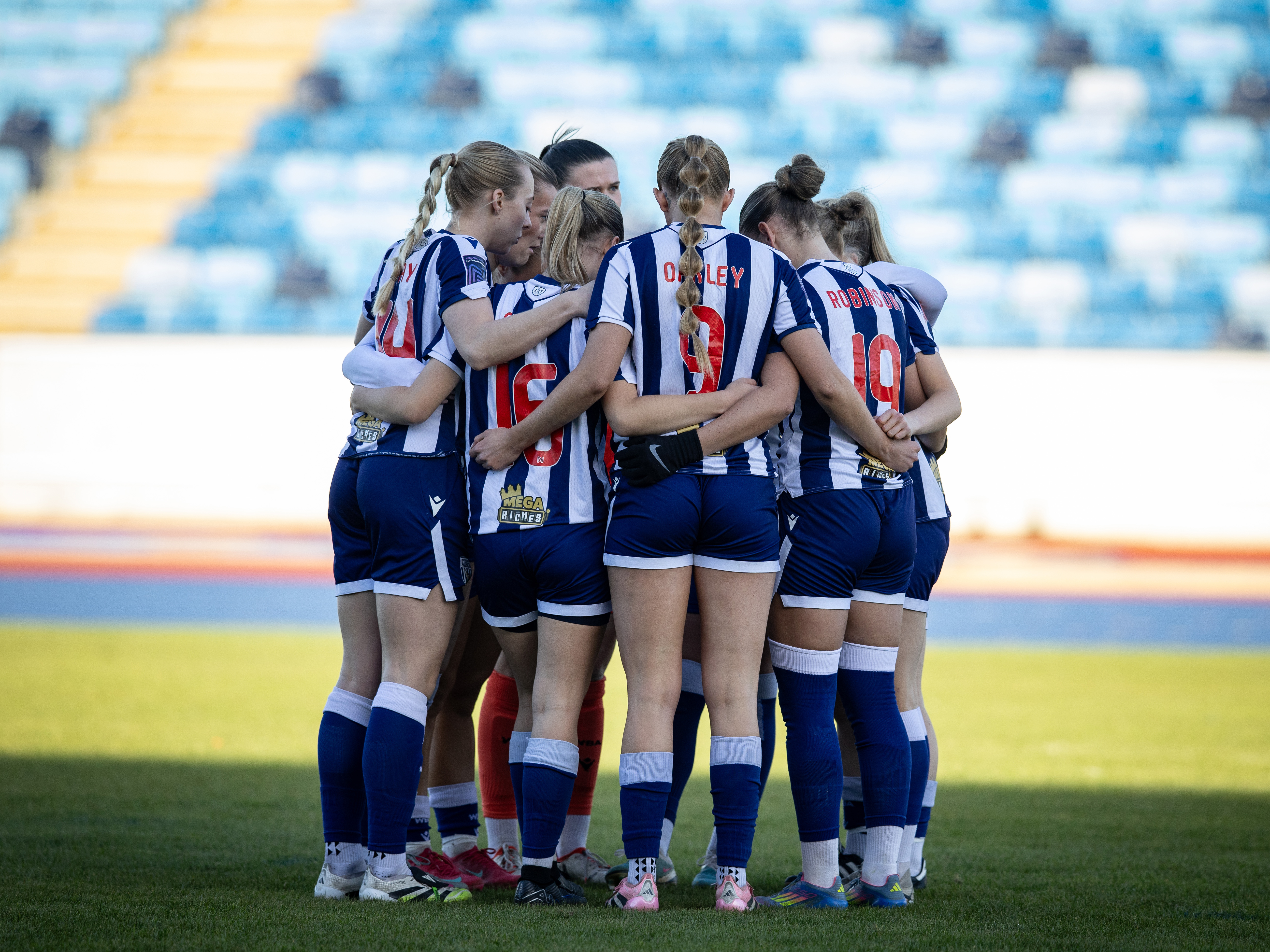 Albion Women in a team huddle.