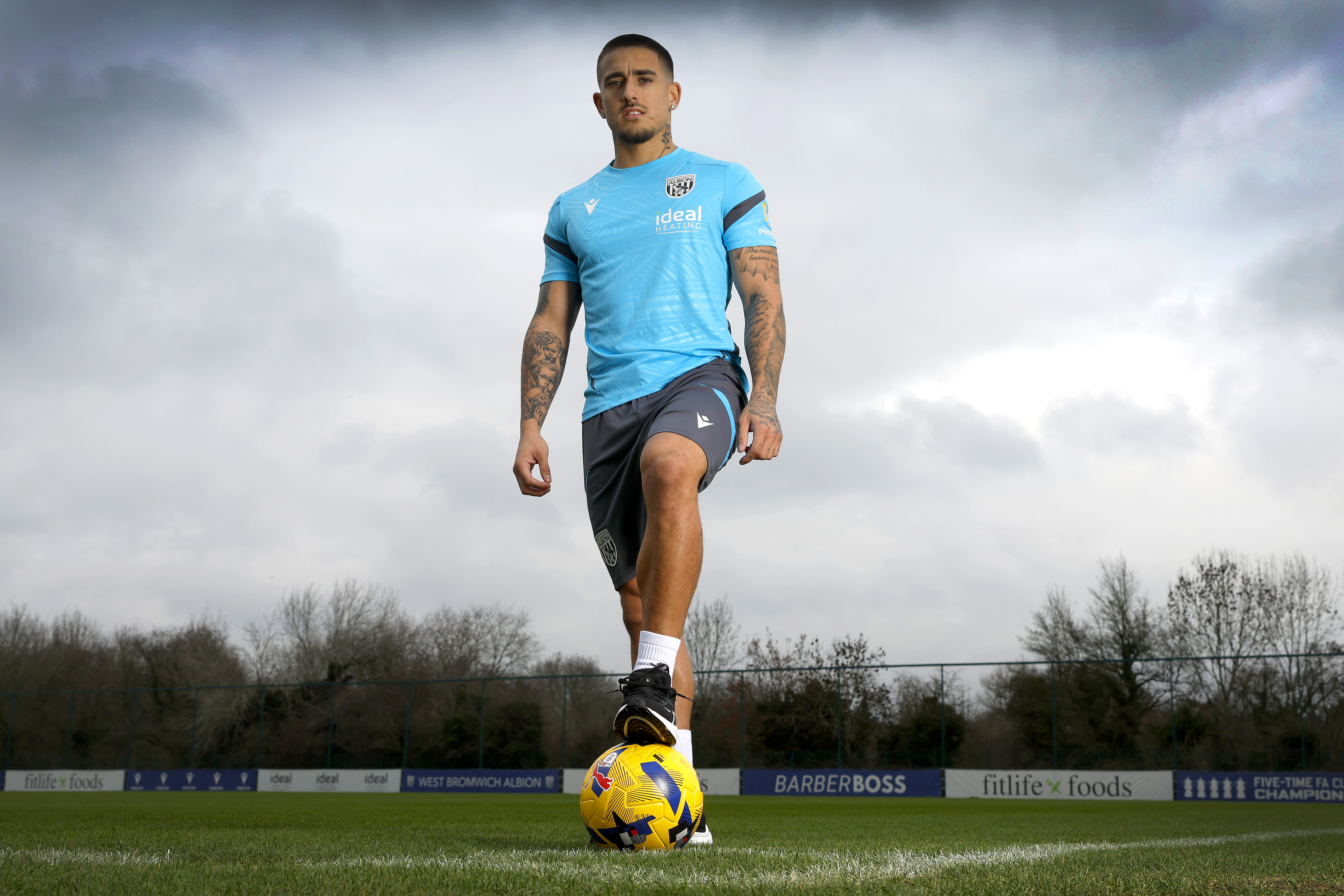 Danny Imray with his foot on a ball out on a training pitch looking directly at the camera