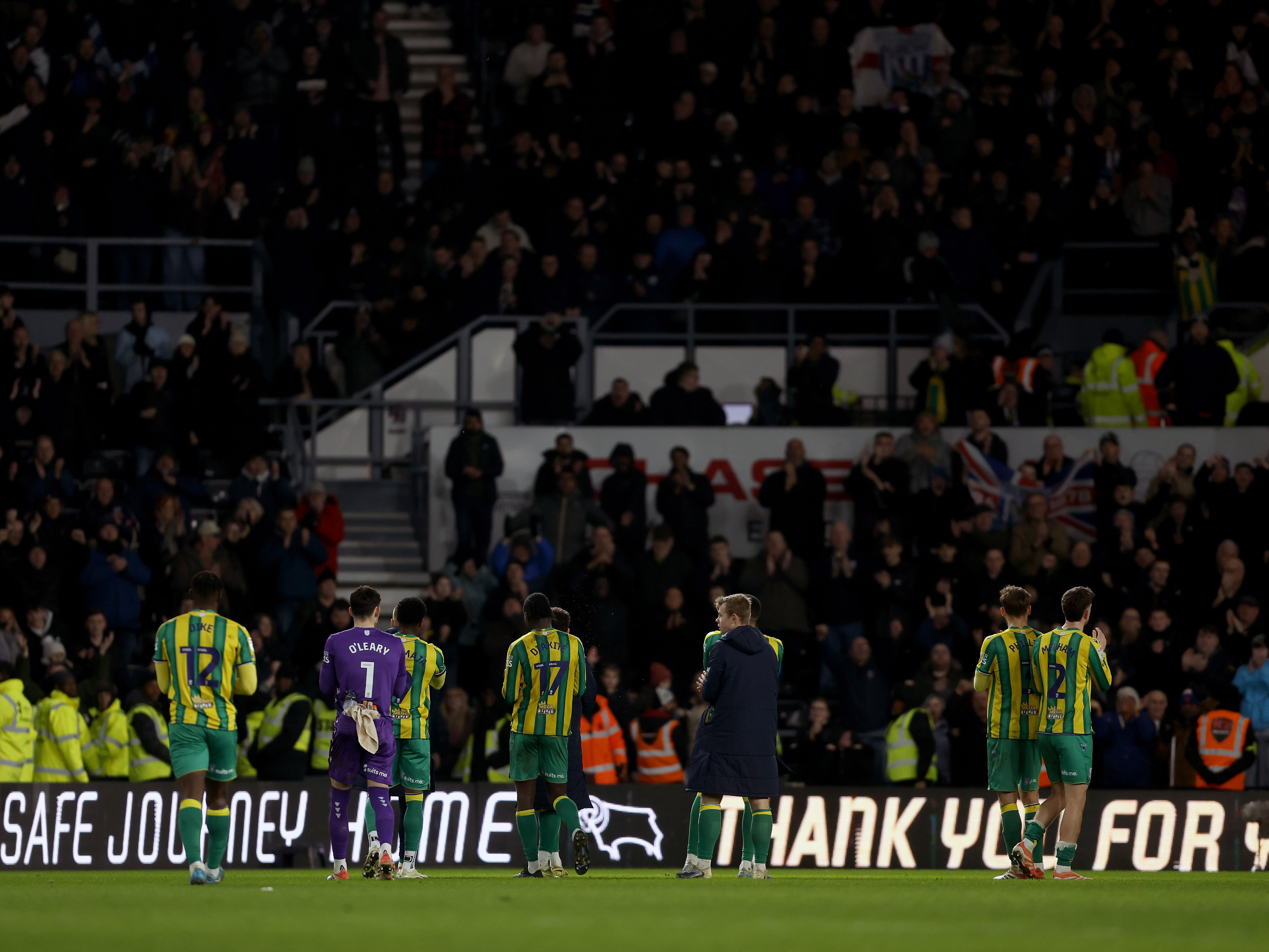 A photo of Albion players, in the green and yellow 2025/26 away kit, applauding the visiting supporters after full-time at Derby