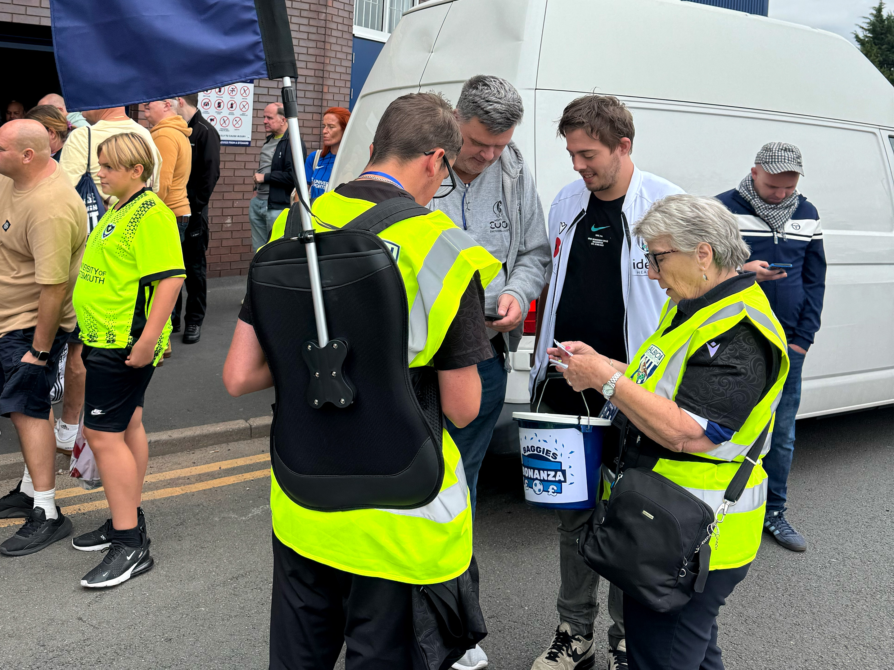 Baggies Bonanza volunteers selling tickets to Baggies fans outside the stadium.