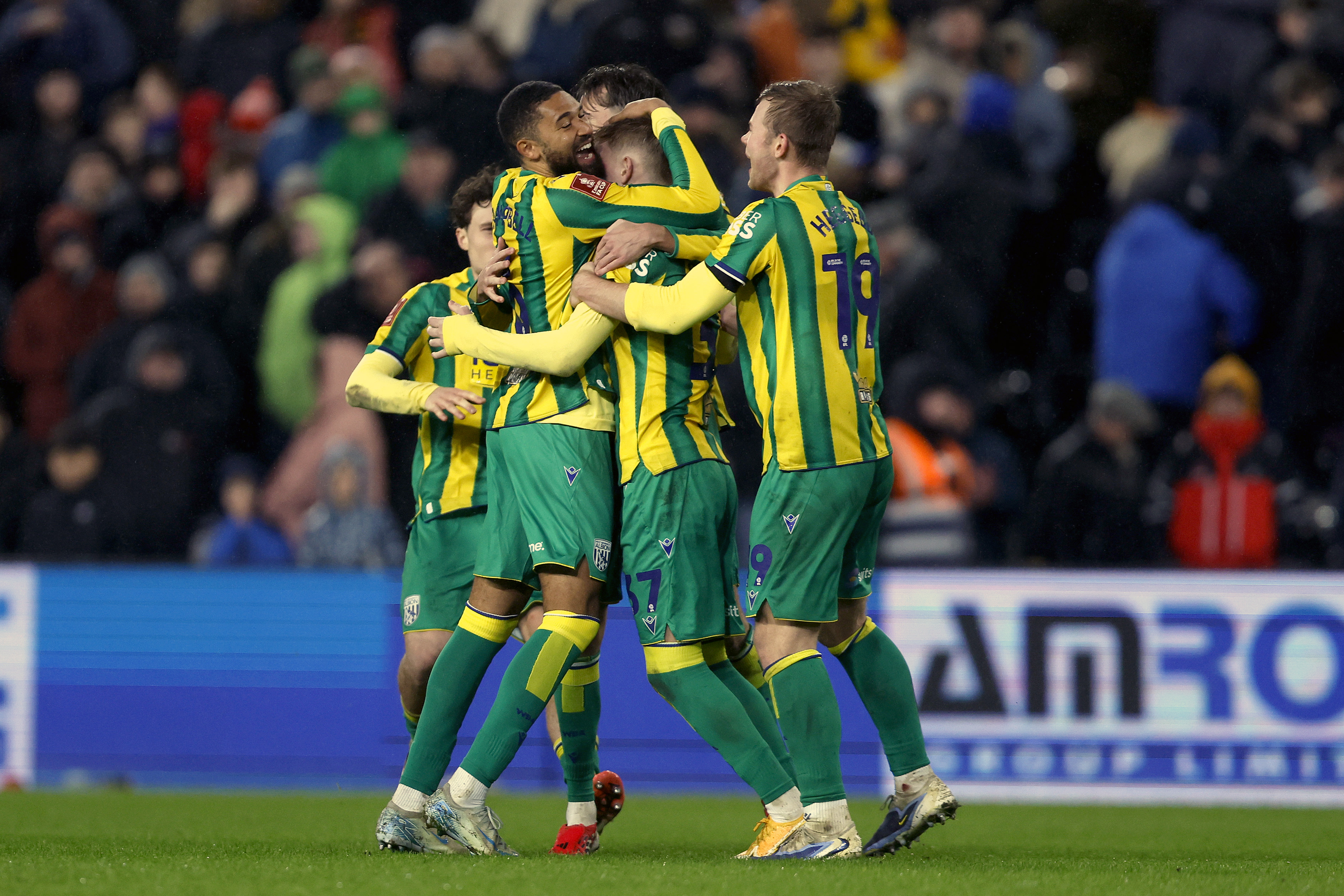 Jed Wallace celebrates with team-mates after scoring at Swansea in the green and yellow away kit 