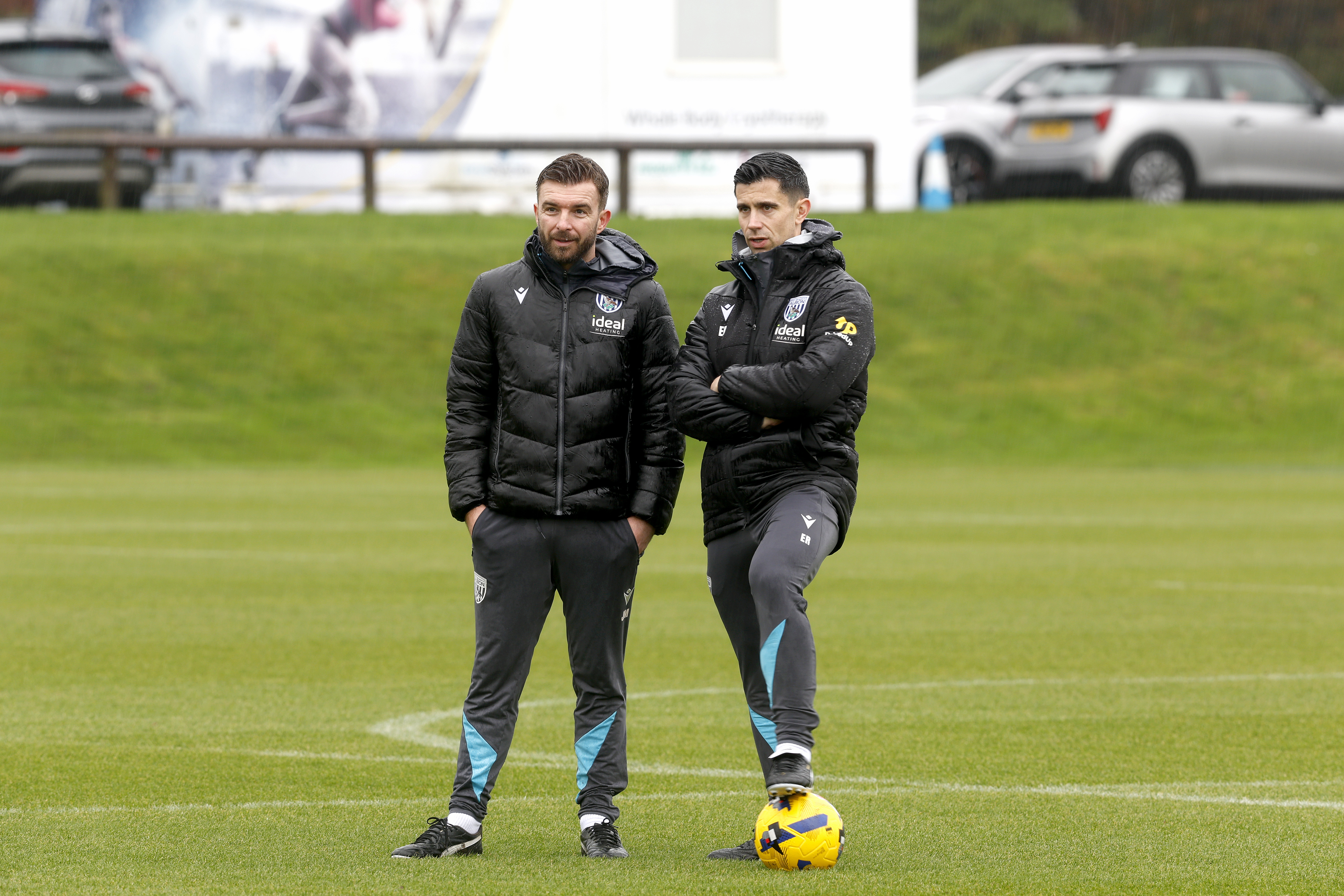 Eric Ramsay and James Morrison talking while watching a training session