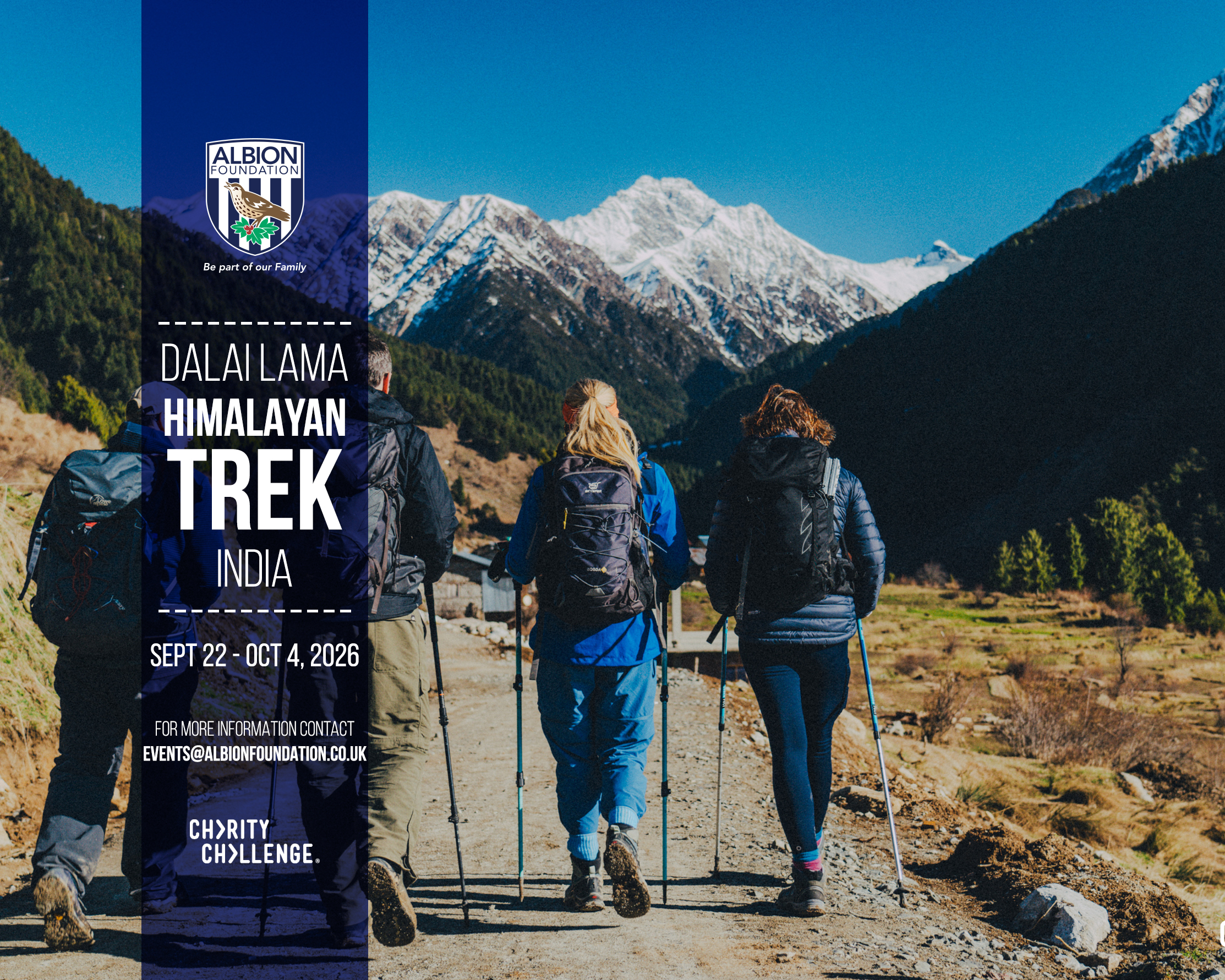Four hikers walking the path with the Himalayan Mountains in the distance