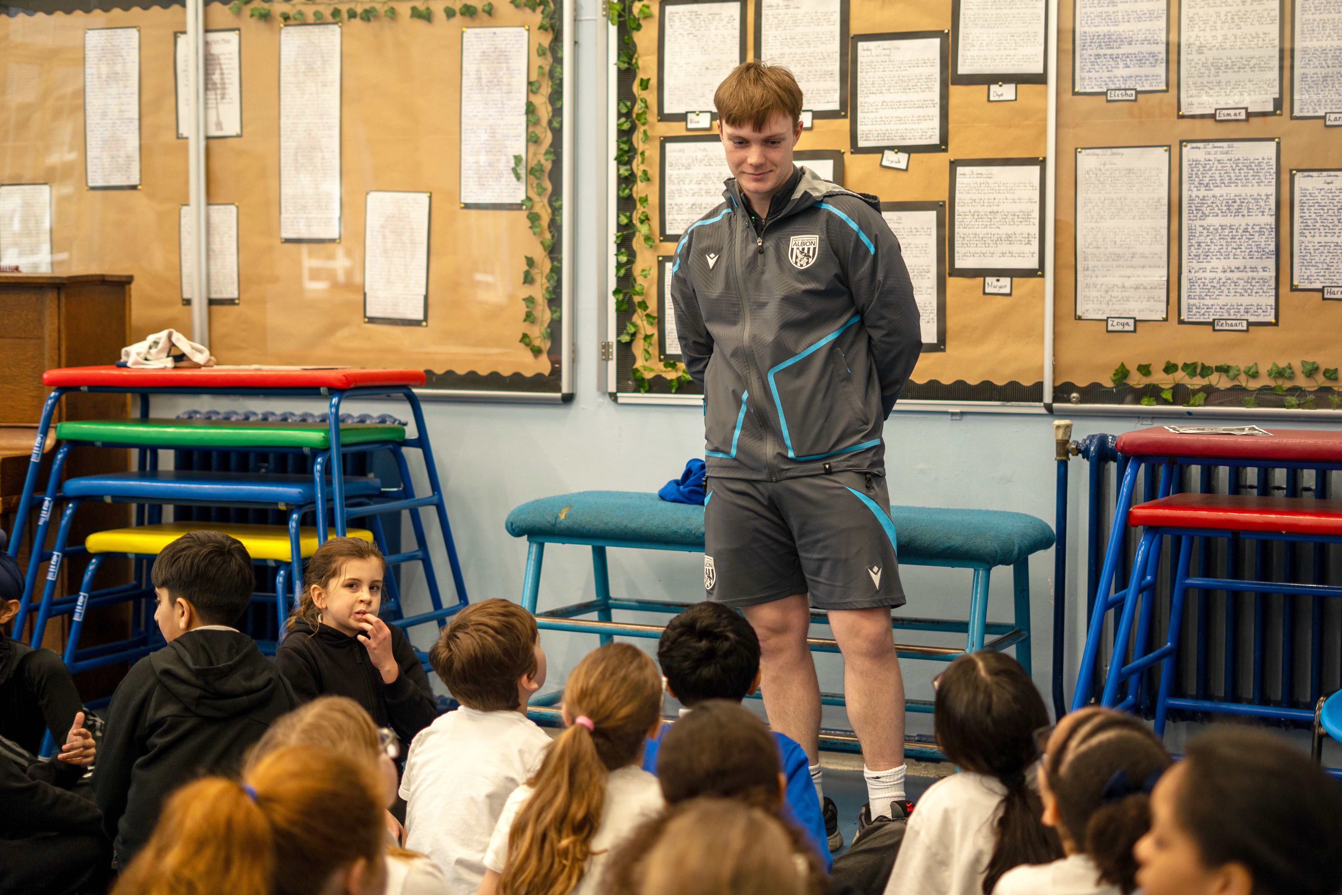Apprentice standing in front of a group of school children.