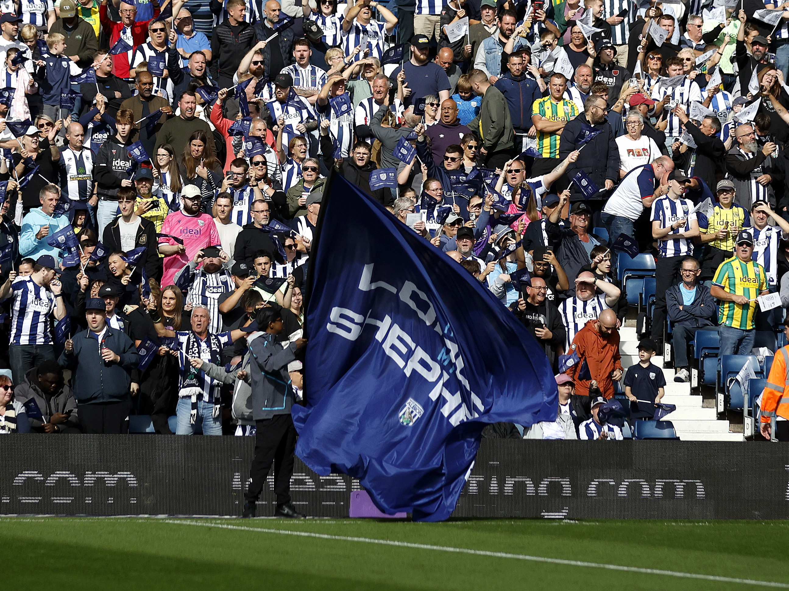 WBA fans inside The Hawthorns with a big flag being waved in front of them