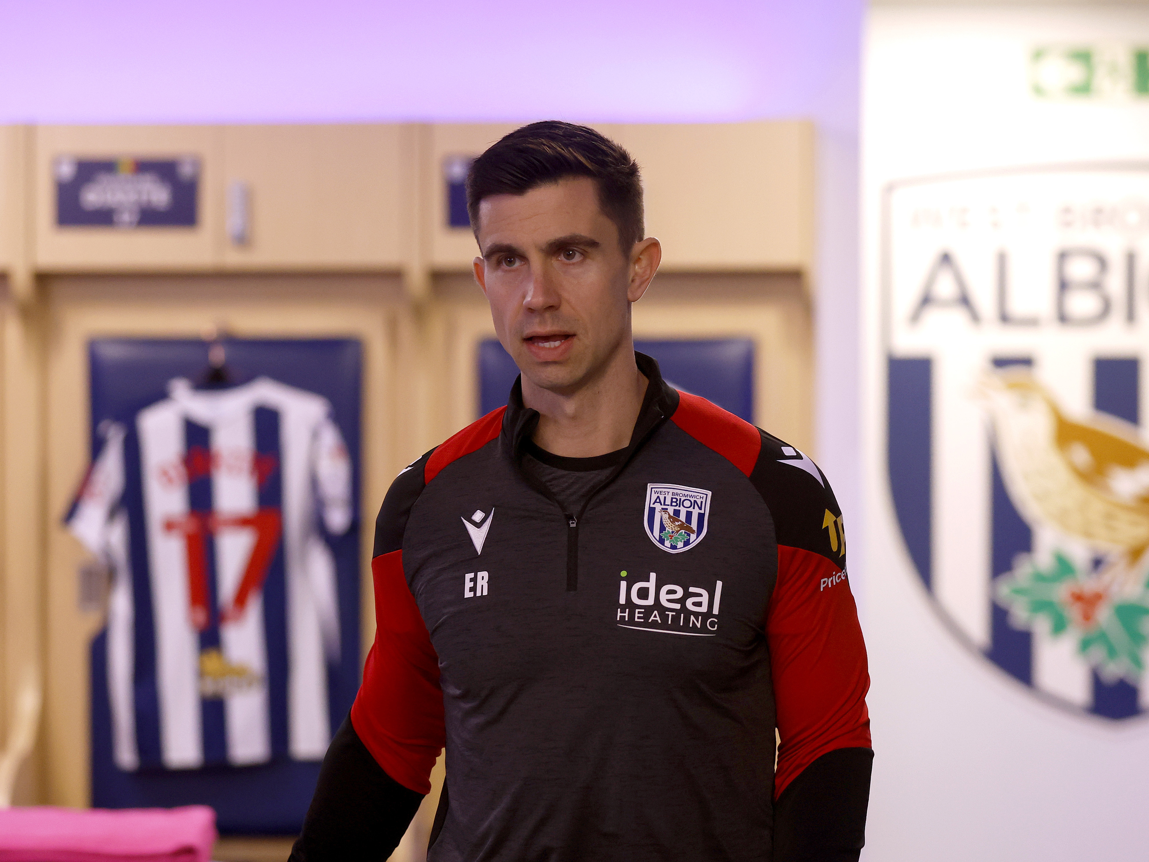 Eric Ramsay in the home dressing room with shirts in the background 