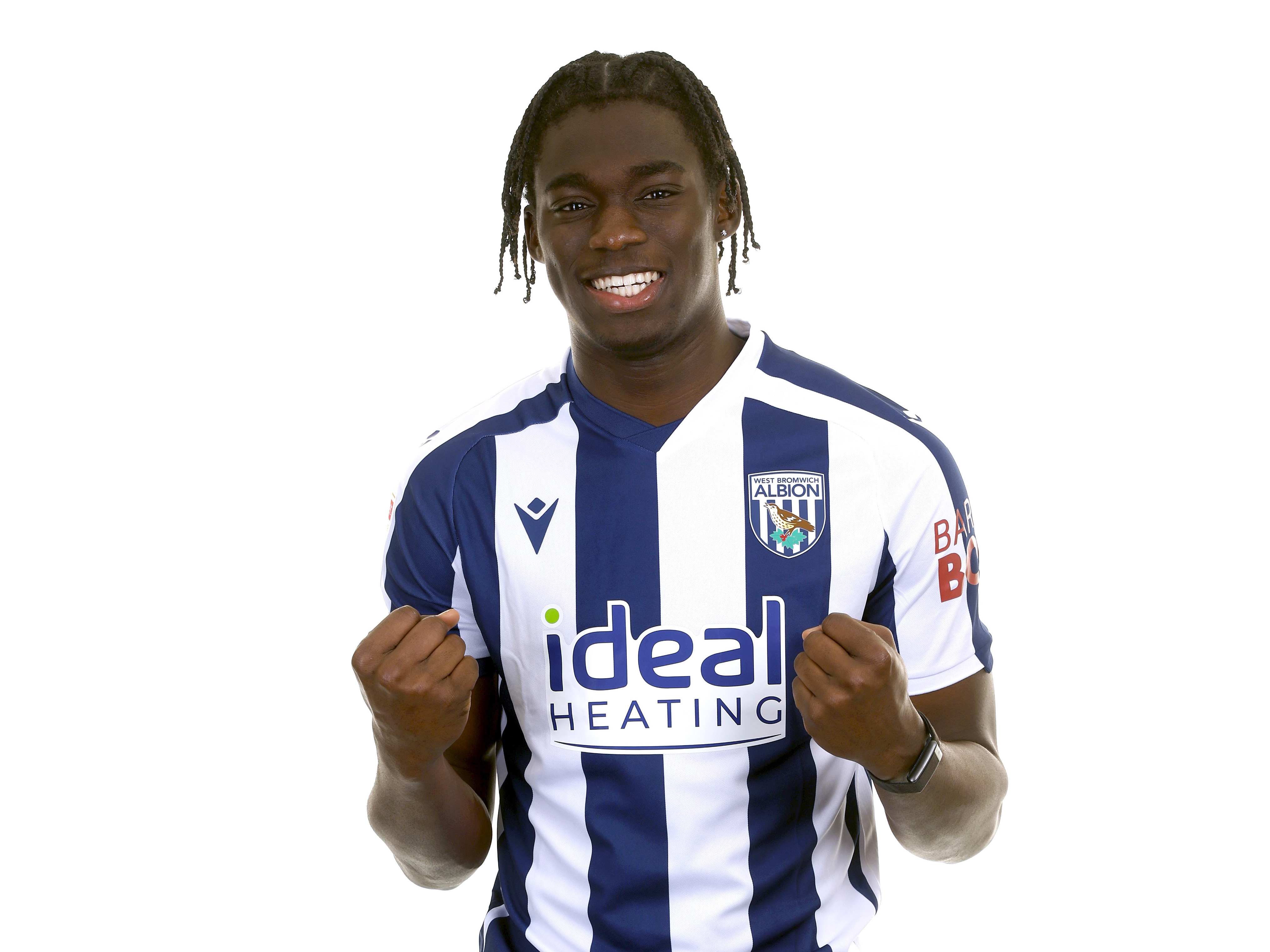 Hindolo Mustapha in the home kit in front of a white background smiling at the camera 