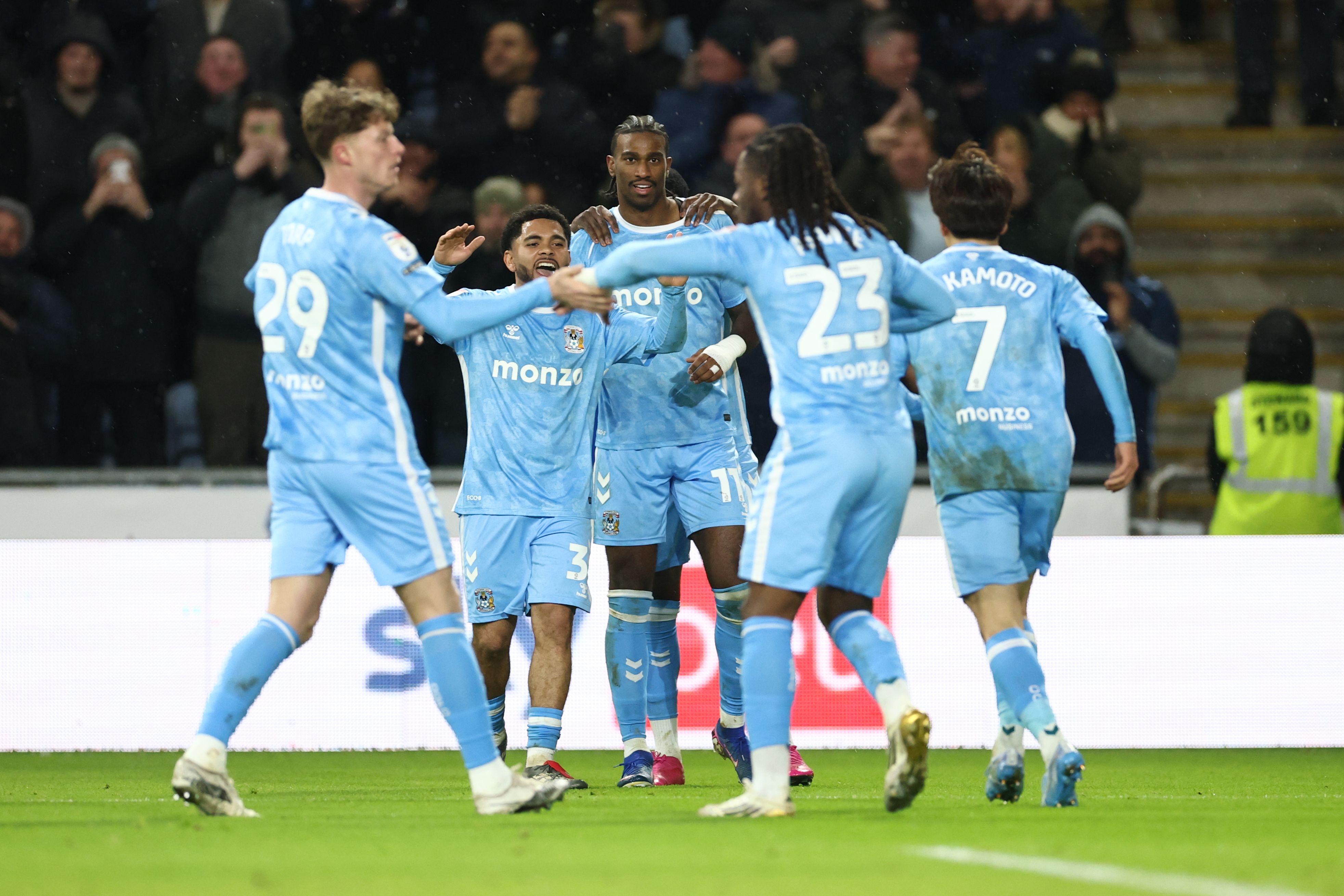 Coventry City players celebrating a goal in their home kit 