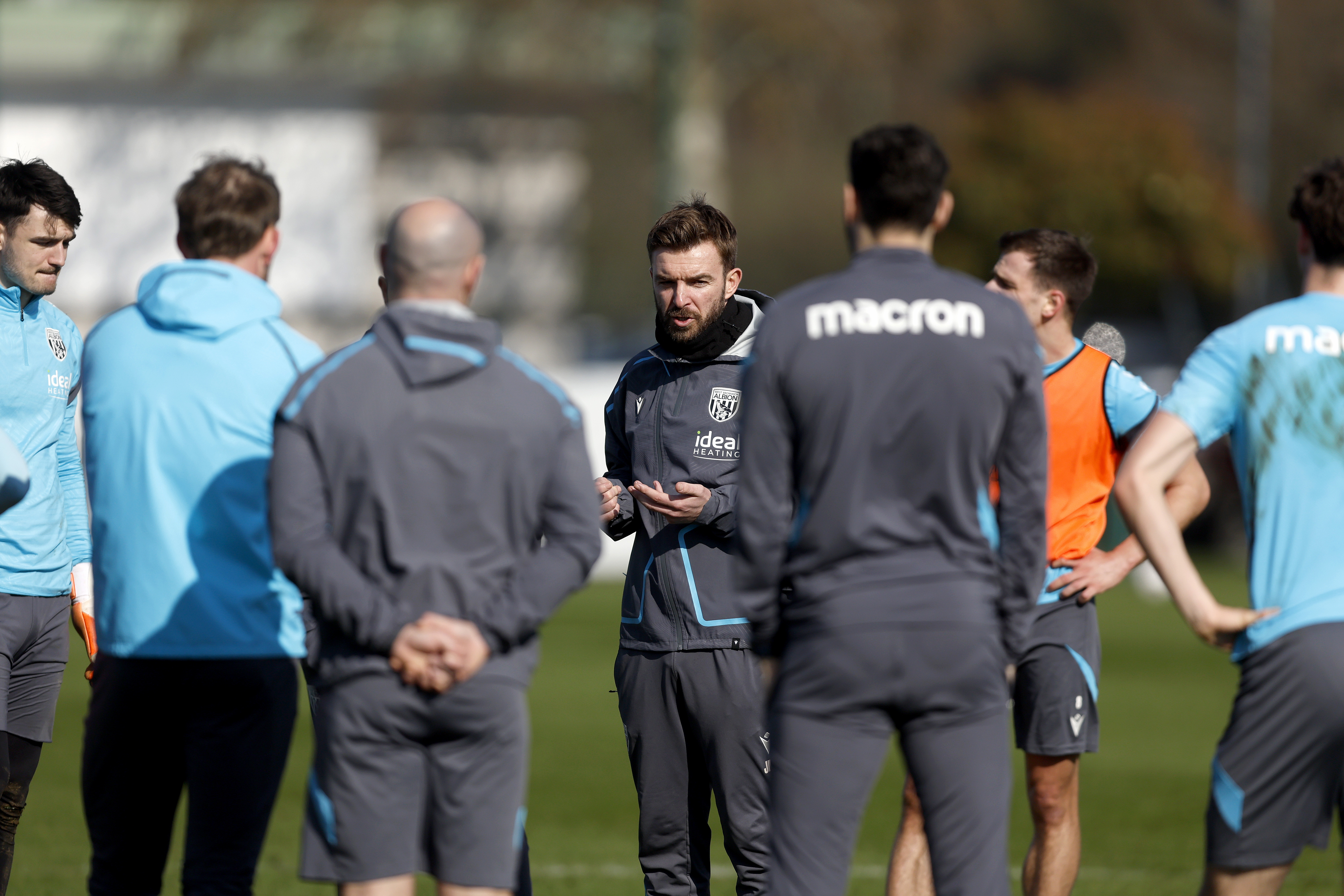 James Morrison talking to a group of staff and players on the training pitch