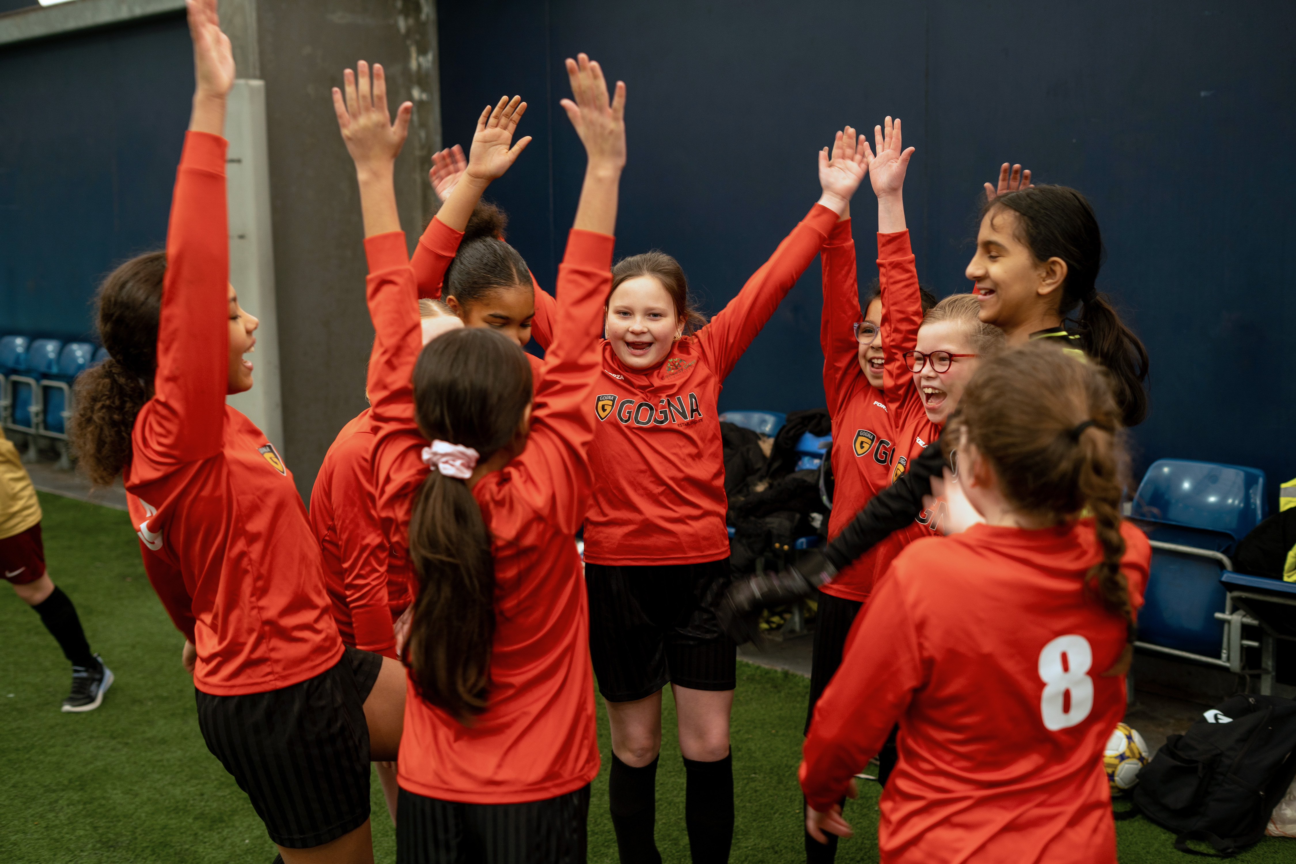 Players with arms raised after a team shout.