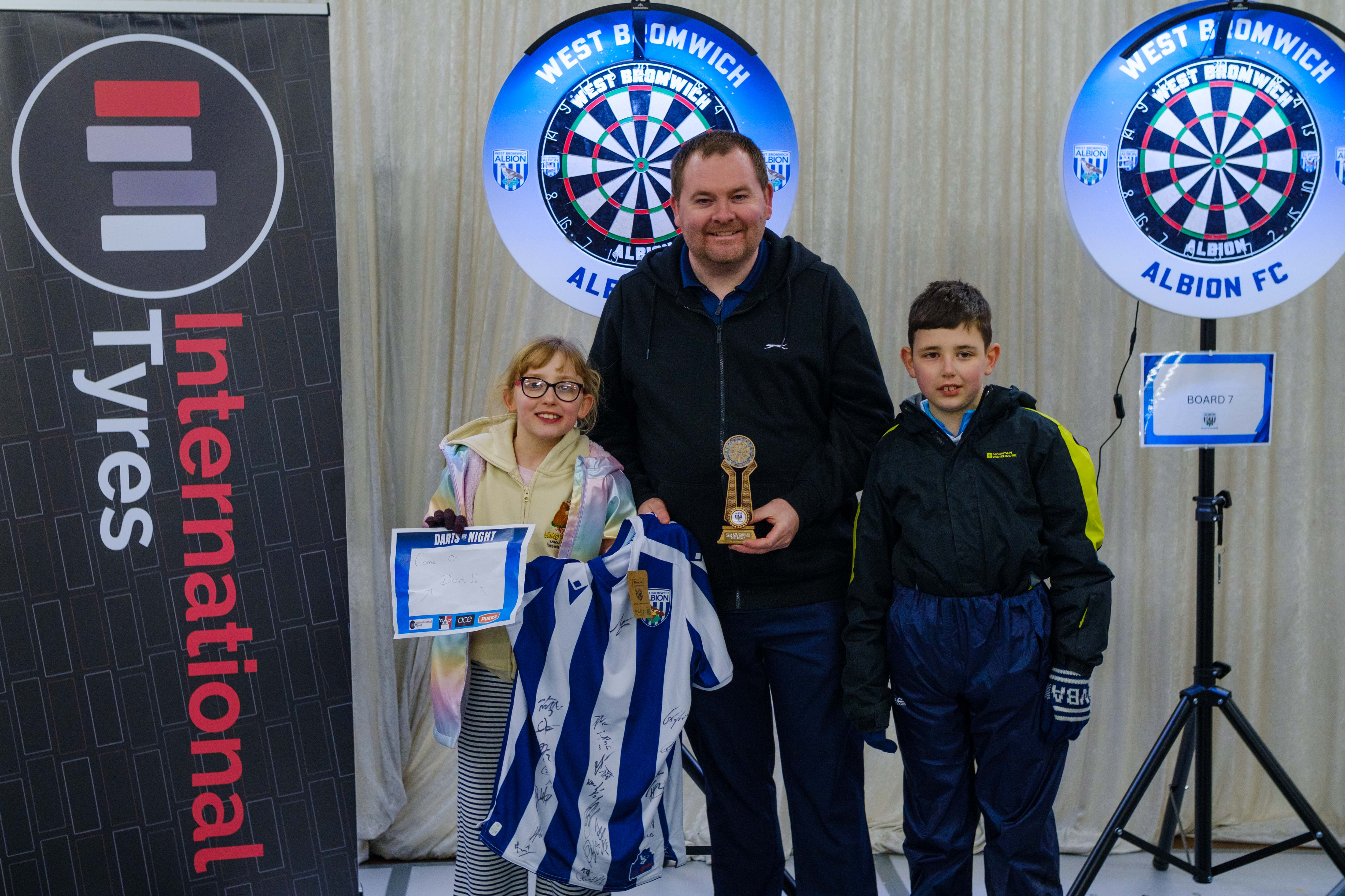 Adult champion Carl Sparrows with his children holding the winners trophy