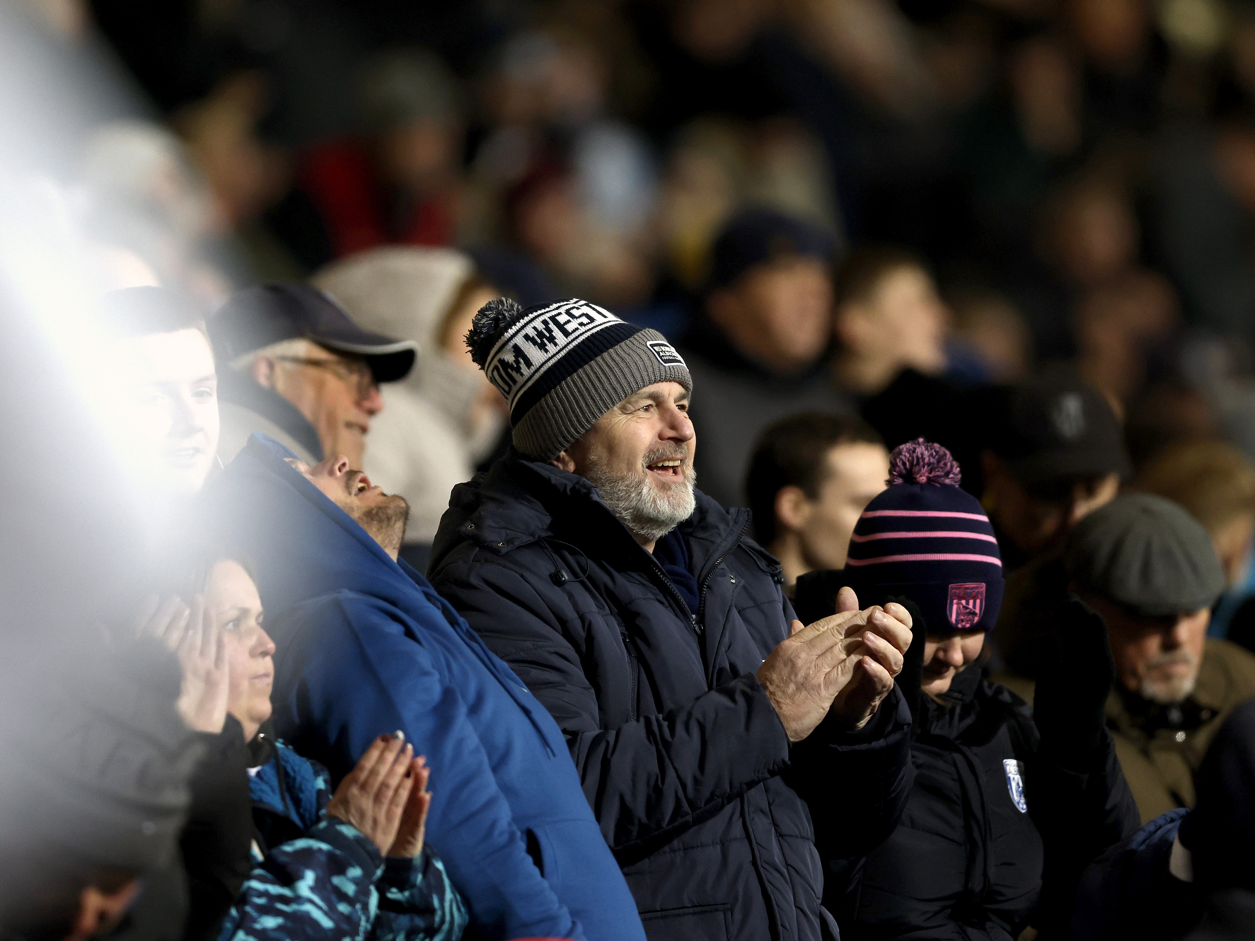 An image of an Albion supporter applauding the team