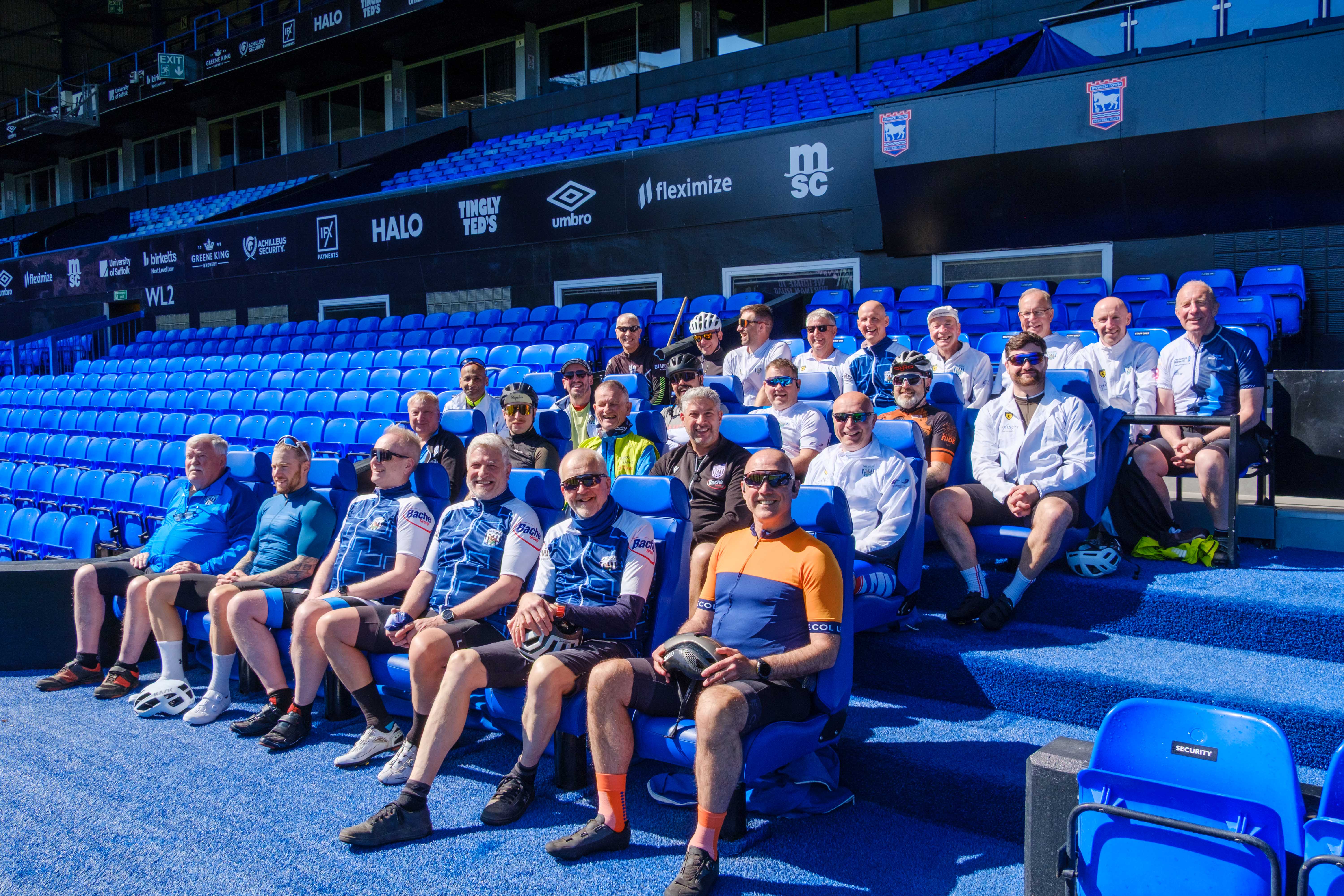 Cyclists seating in the Ipswich dugout