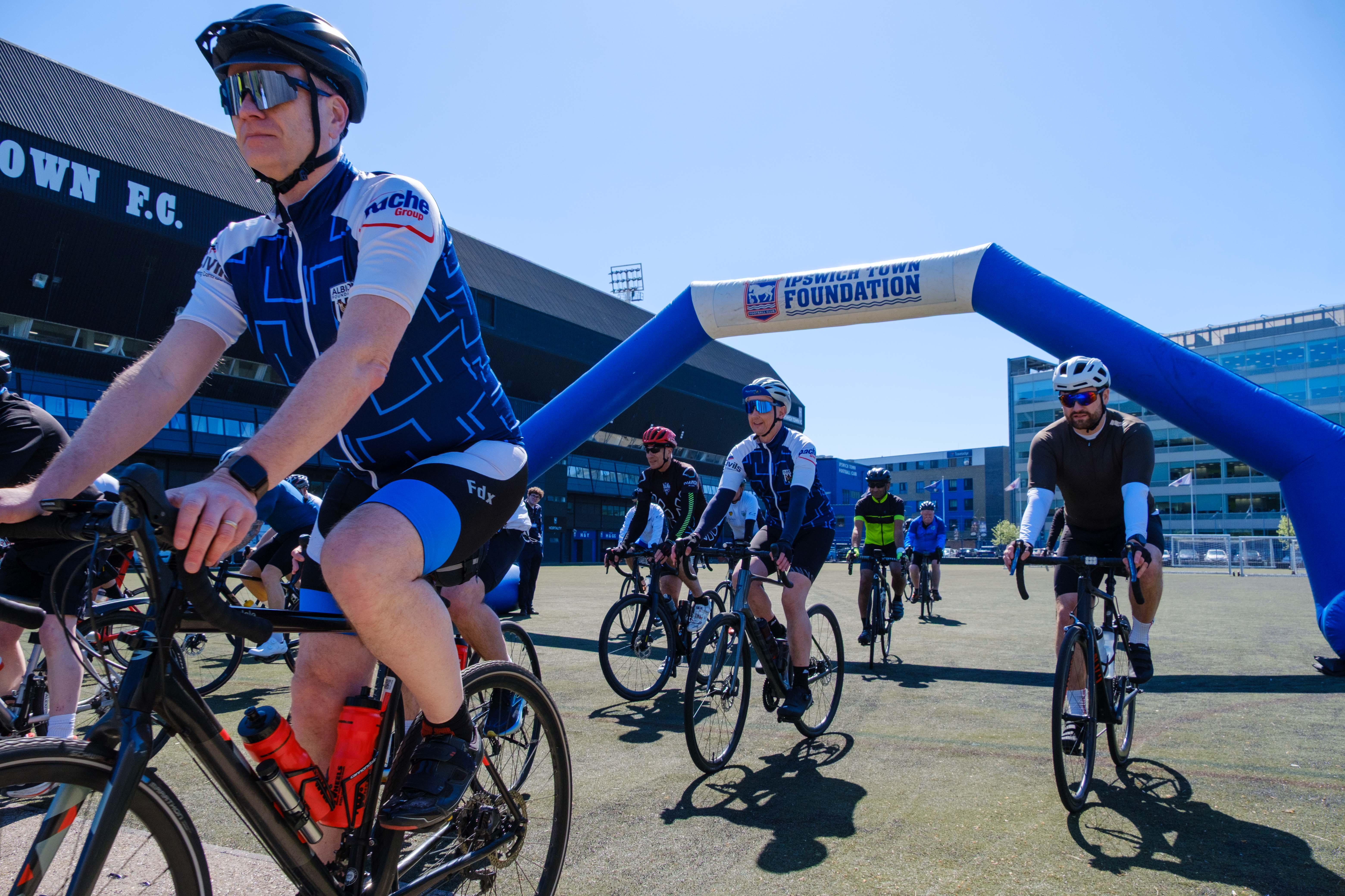 Cyclists riding through the inflatable arch.