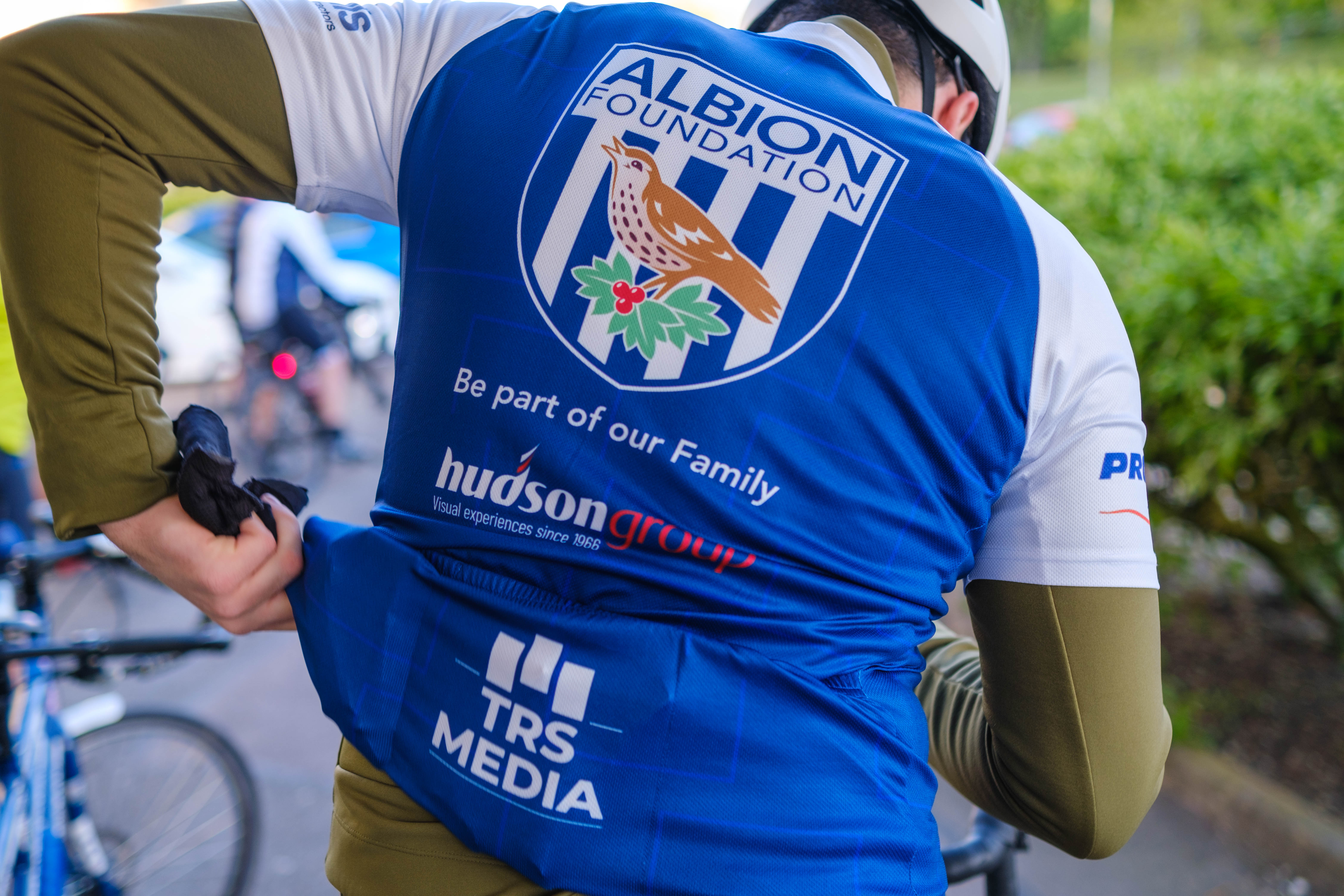 Reverse of cyclist jersey with Foundation badge, Hudson Group & TRS media on display.