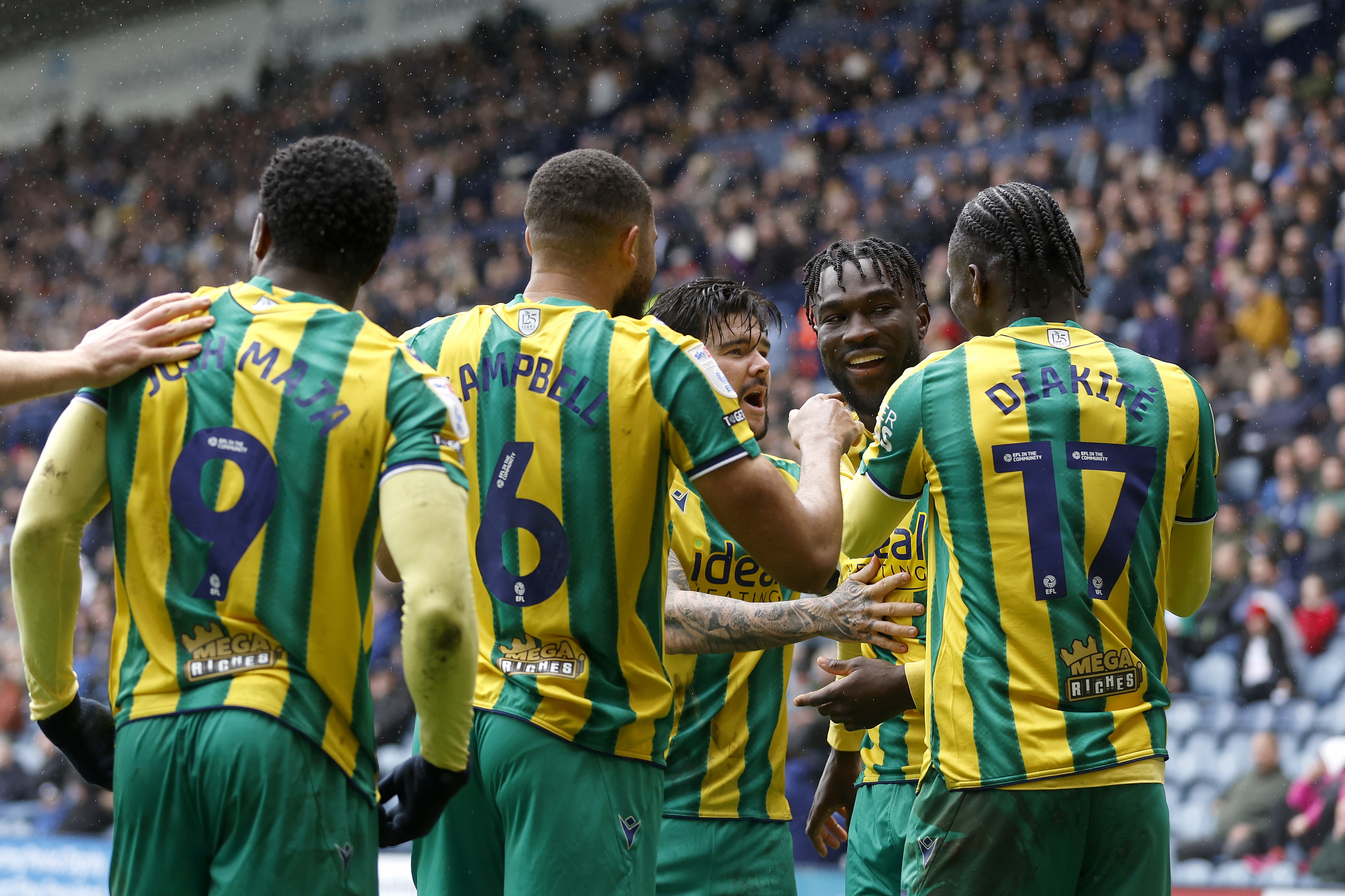 Daryl Dike celebrates with team-mates after scoring at Preston in the green and yellow 