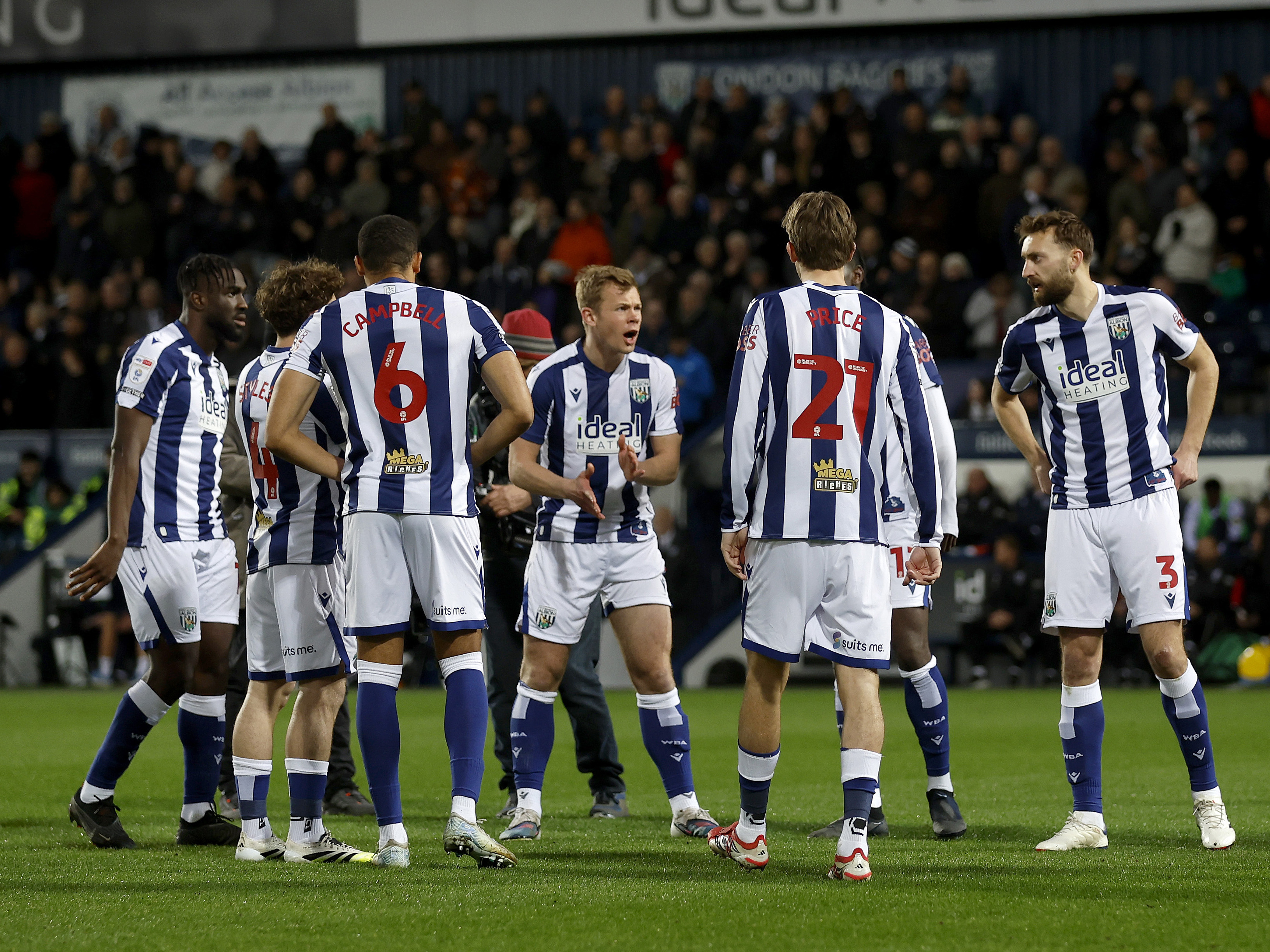 Several WBA players in a group on the pitch before the Millwall game 
