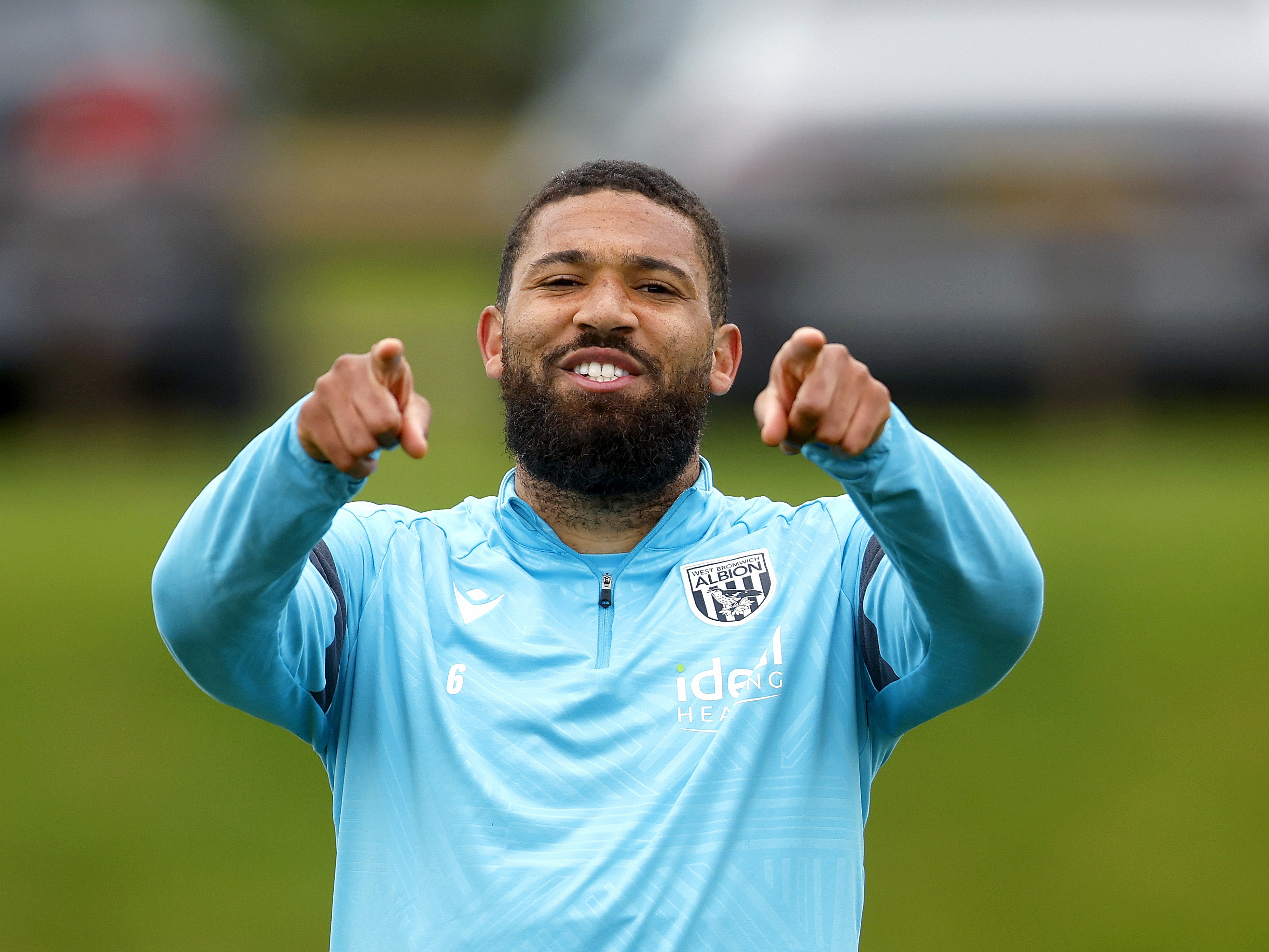 George Campbell smiling and pointing at the camera during a training 