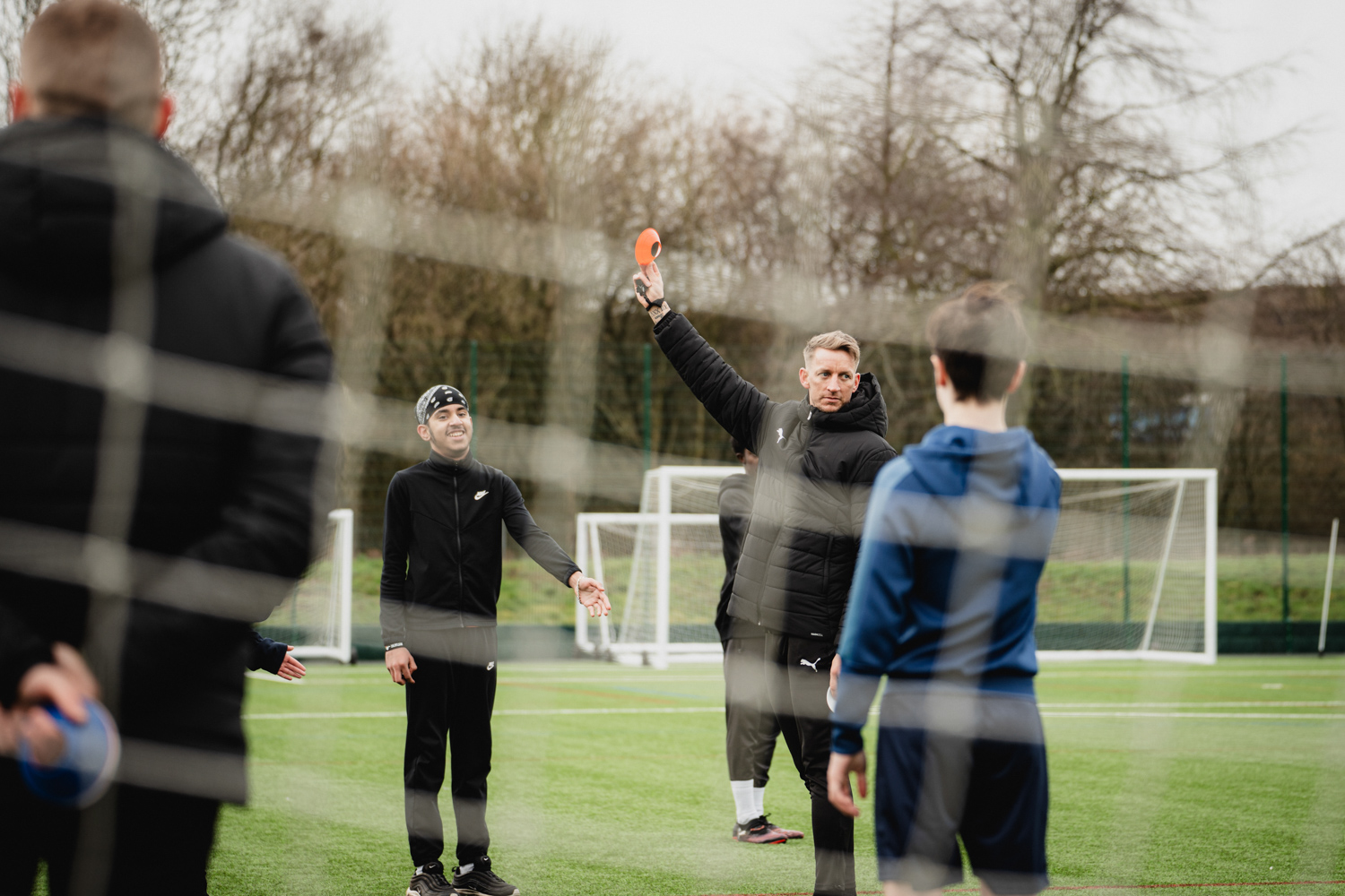 Will Finnie holding up a mini red cone as participants look on.