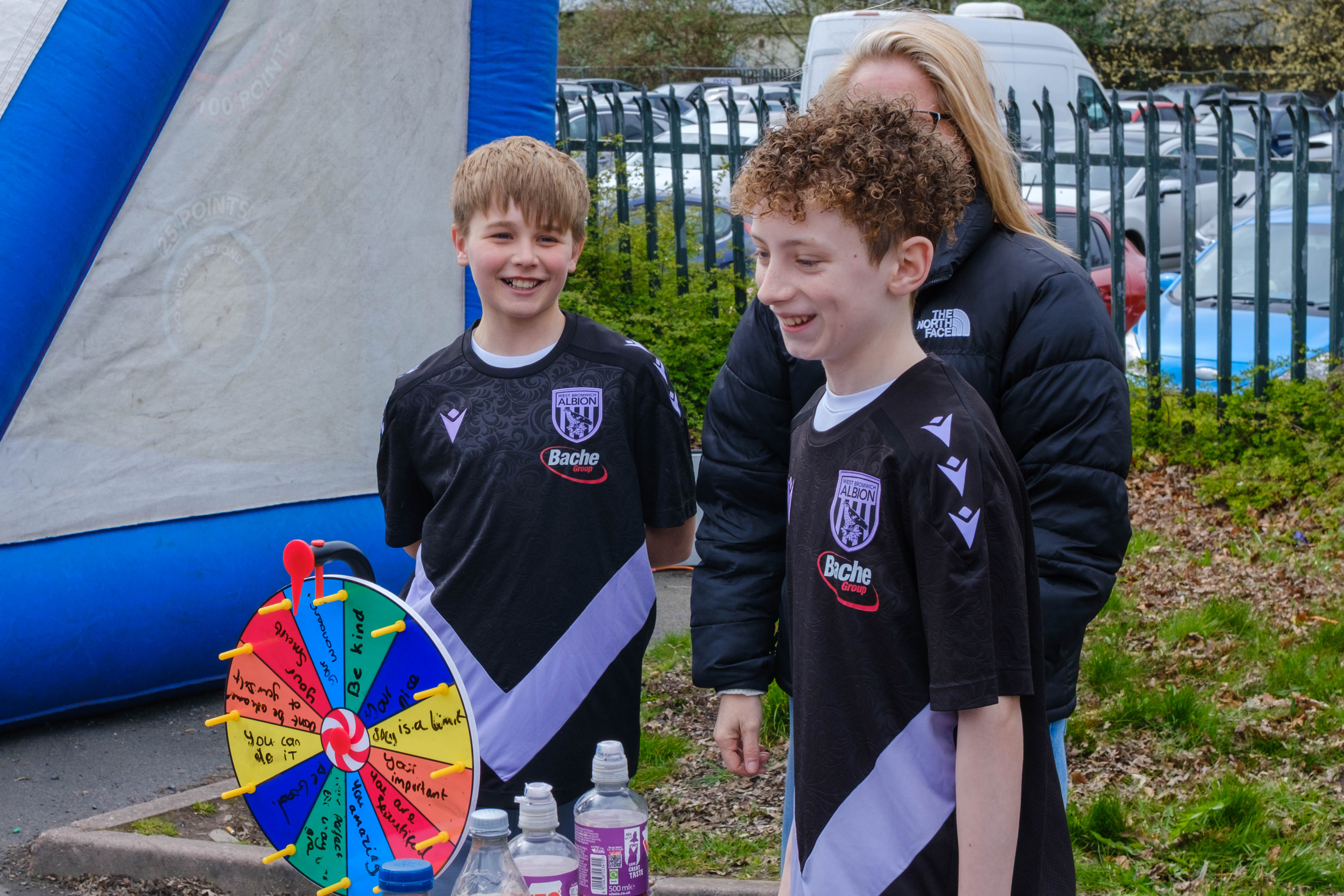 Two students smiling behind their display table in the WBA Fanzone