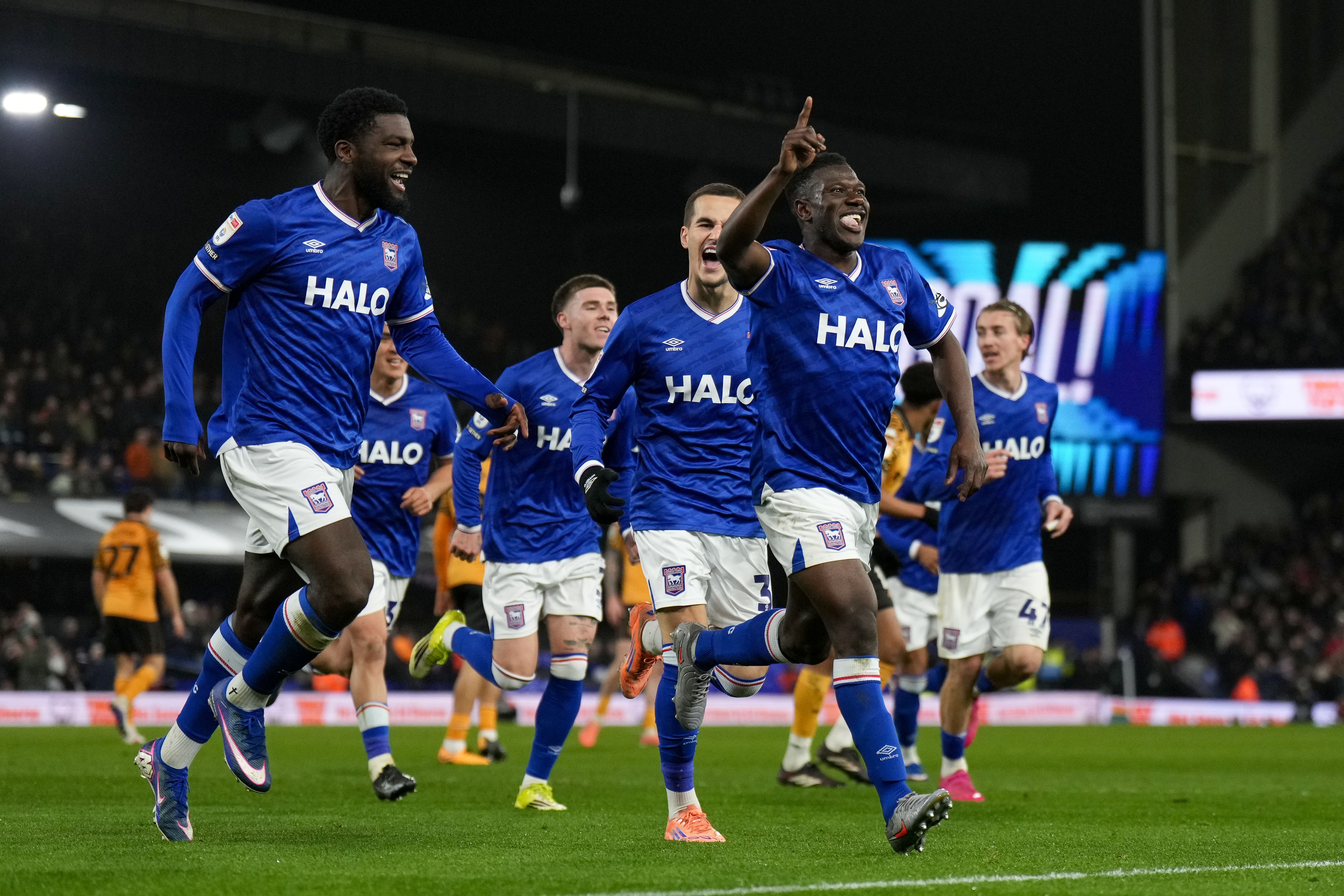 Several Ipswich Town players celebrate a goal scored while wearing the home kit 