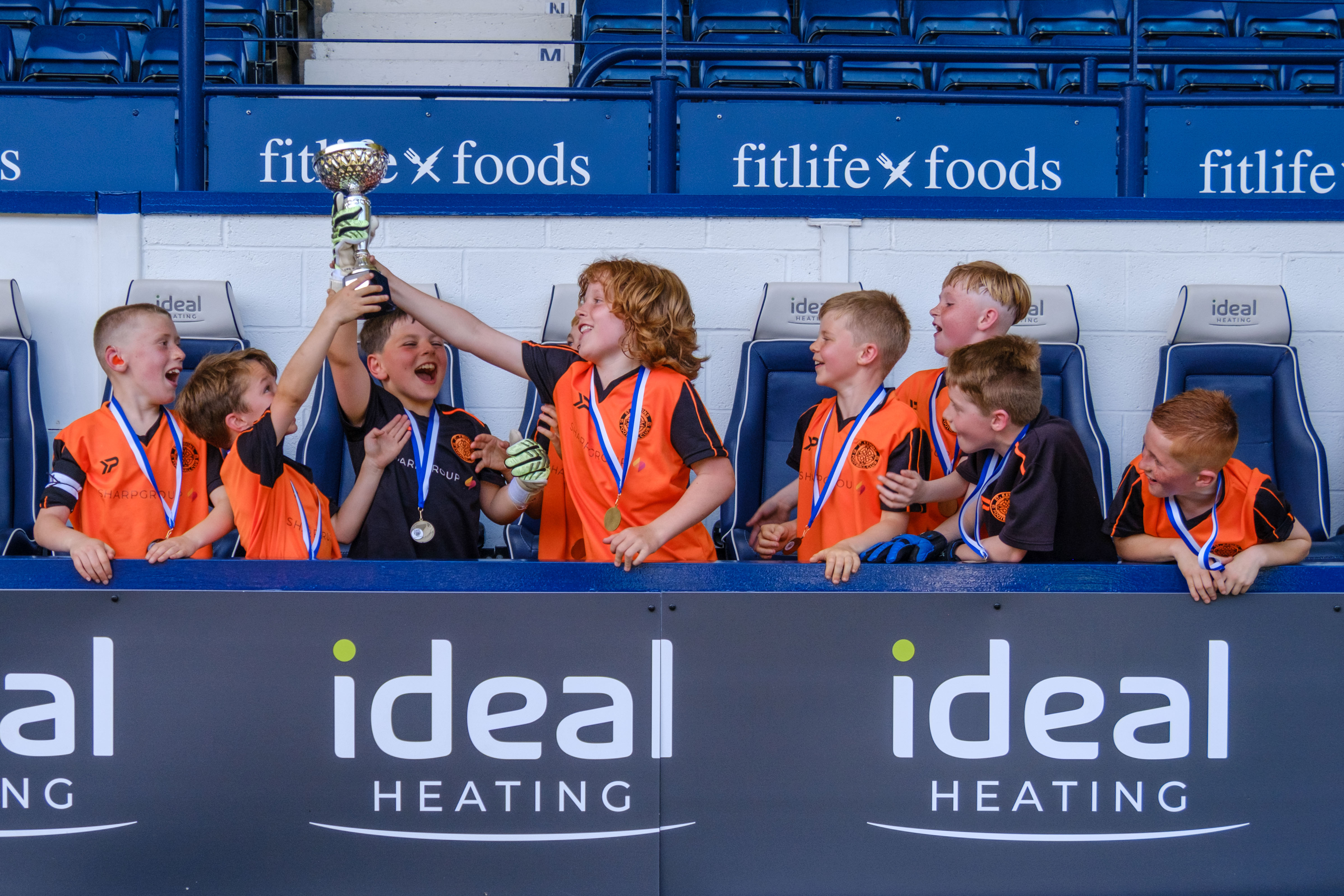 St. Kevin's FC lifting the trophy in the dugout.