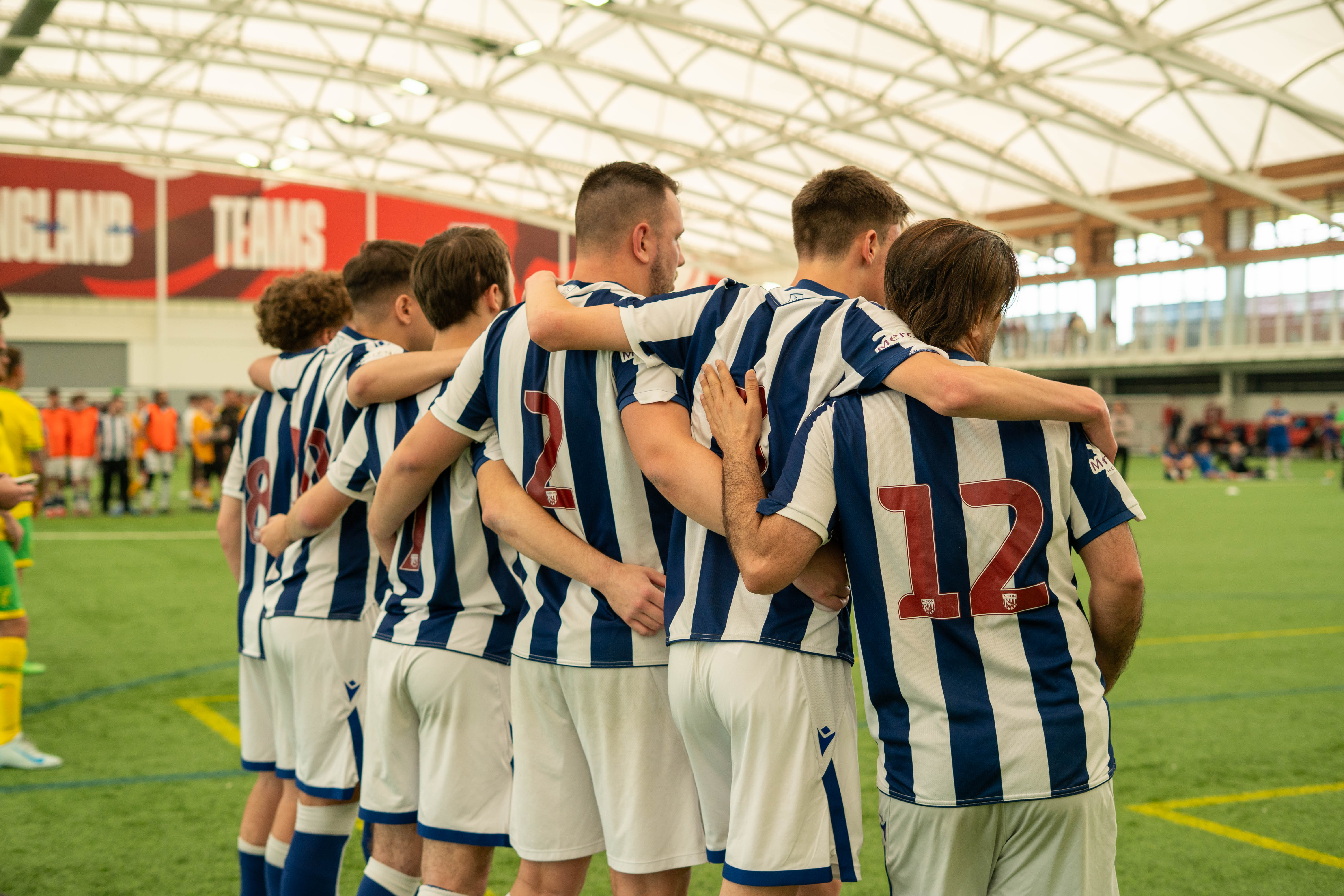 Backs for WBA Cerebral Palsy players arm in arm during penalty shootout.