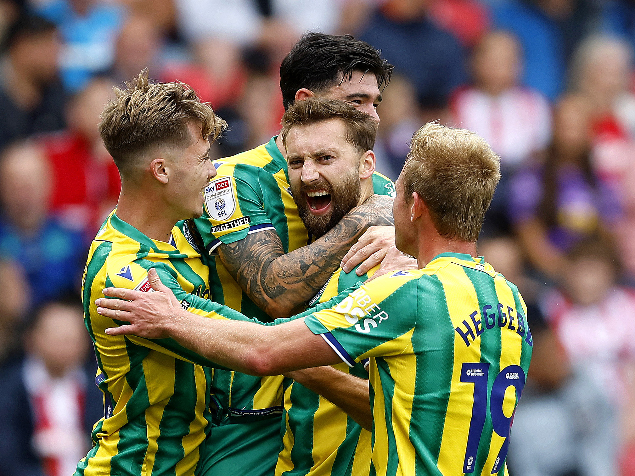 Nat Phillips celebrates scoring at Stoke City in the green and yellow away kit with Alex Mowatt, Isaac Price and Aune Heggebø