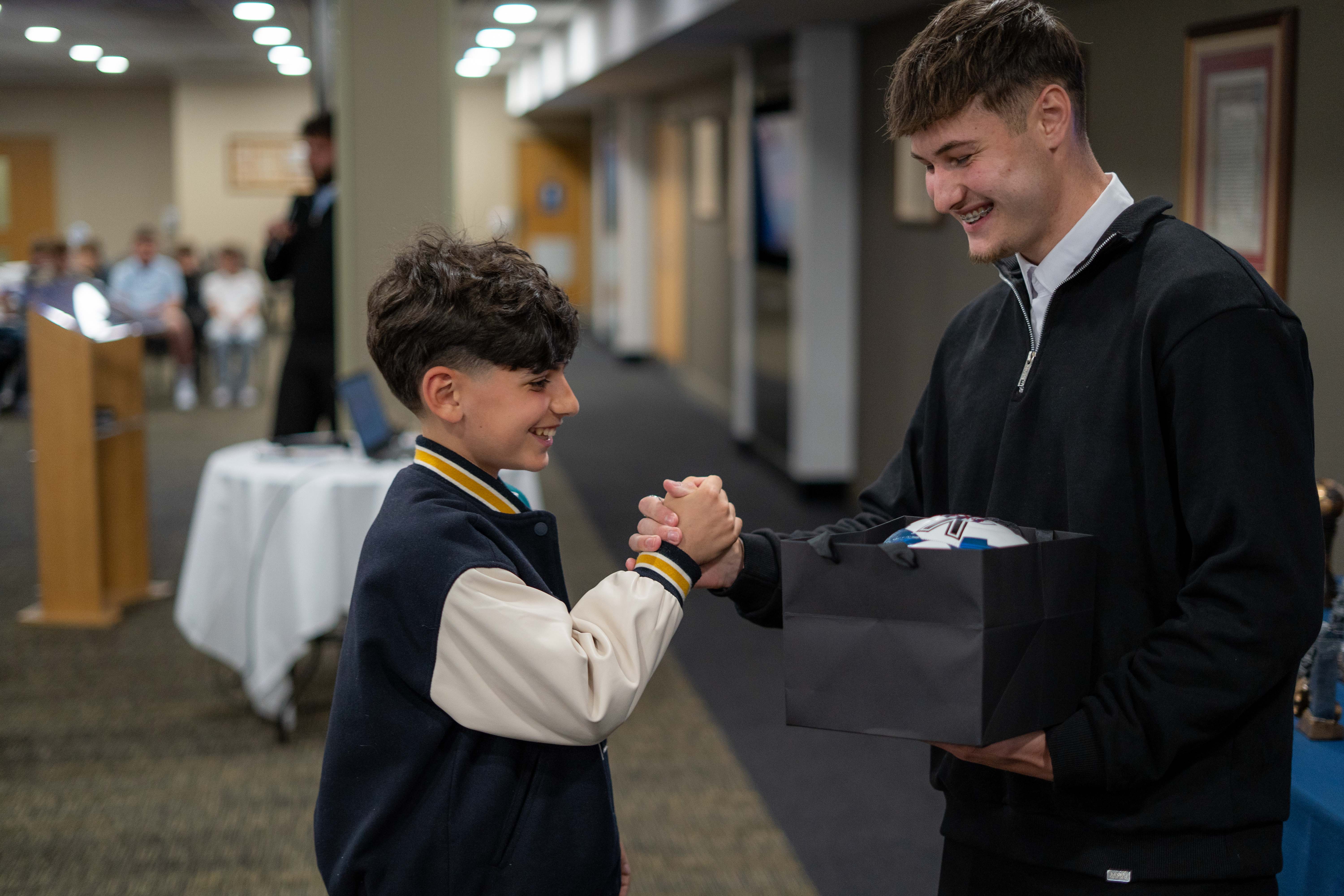 MJPL player and coach, both smiling, sharing a handshake