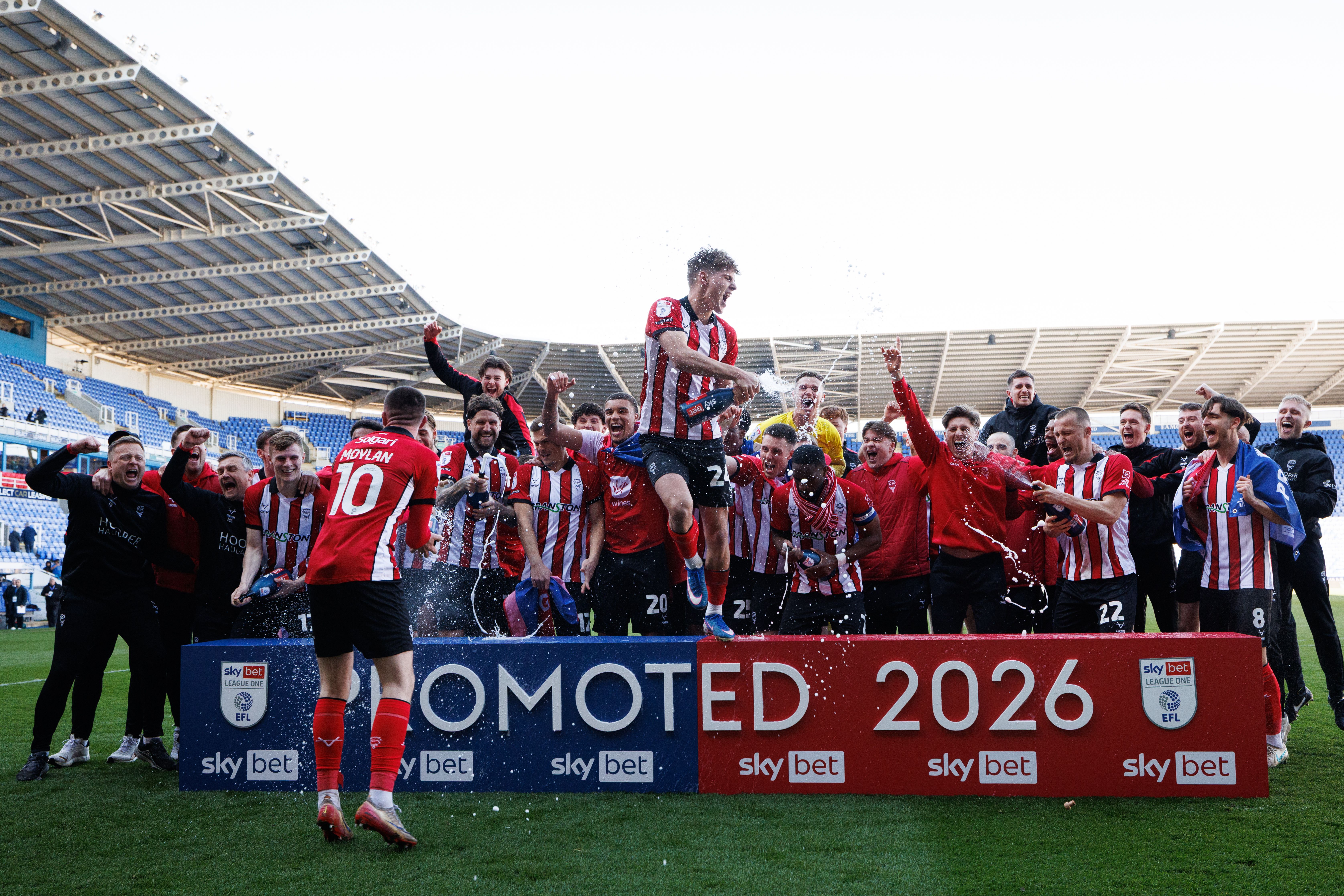 Lincoln City players and staff celebrate winning Sky Bet League One title 