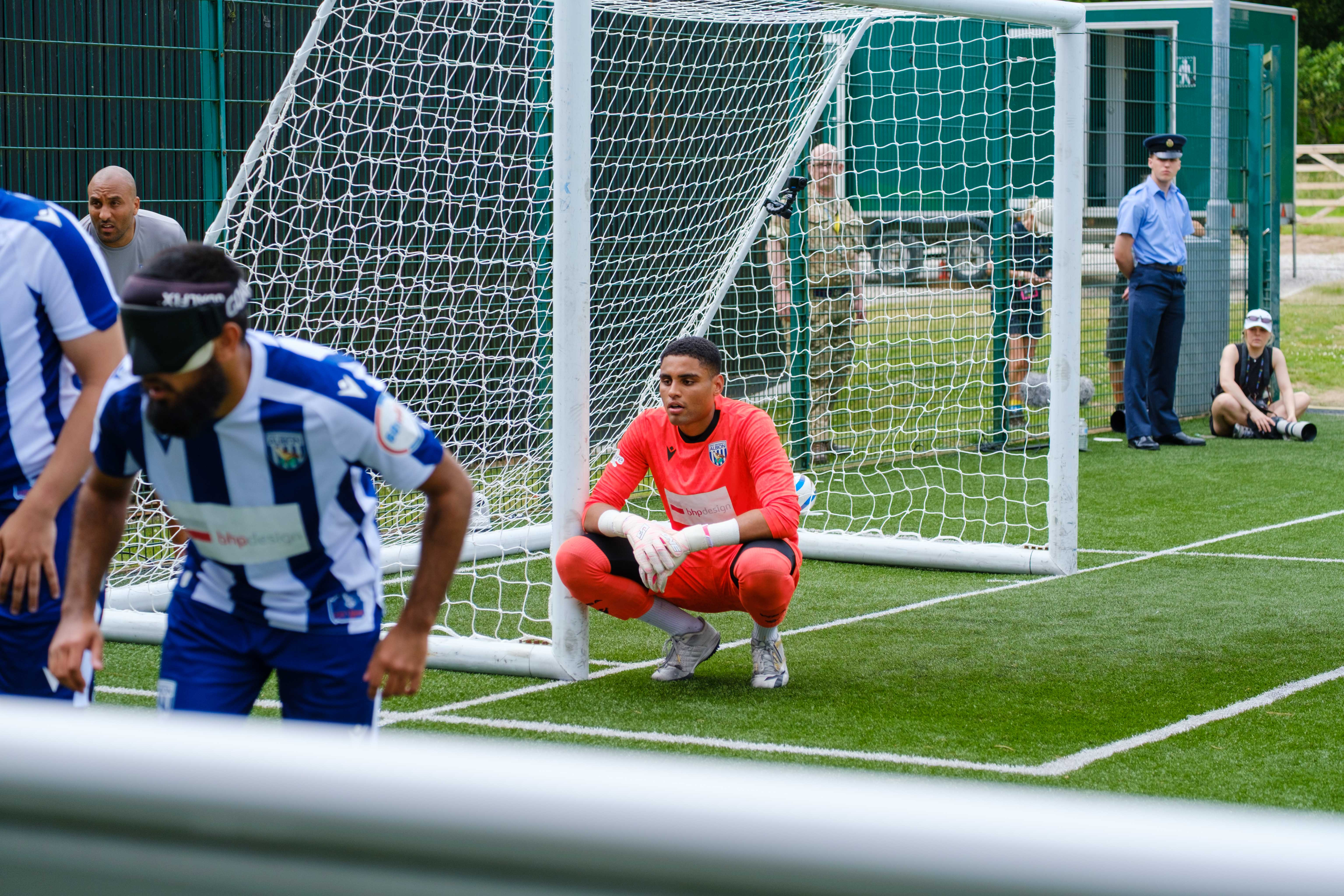 Goalkeeper Owen Locke, kneeling, as Eesa and others set up in a wall to defend a RNC corner.