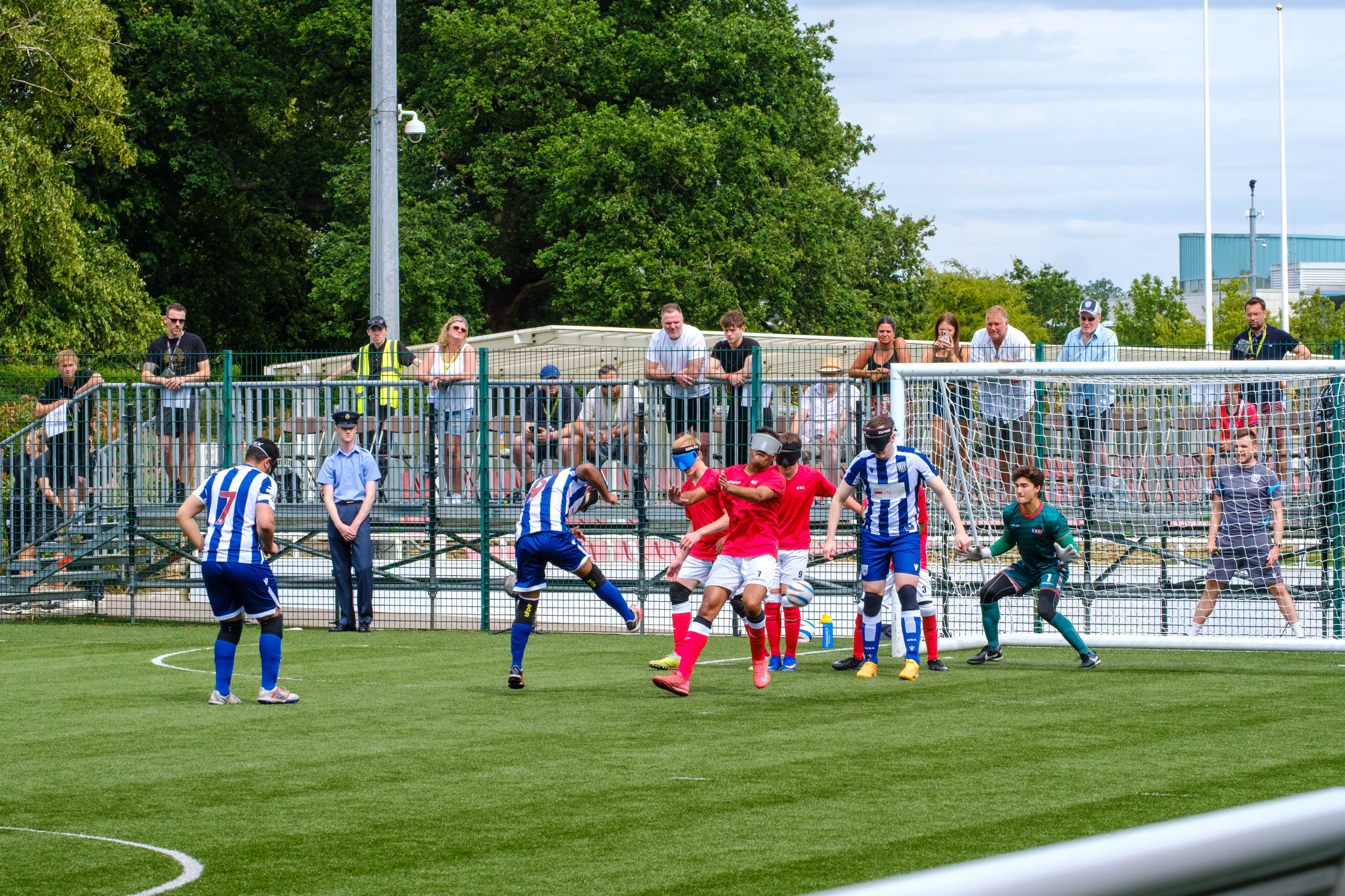 Eesa striking the ball with a sea of players in front of goal.