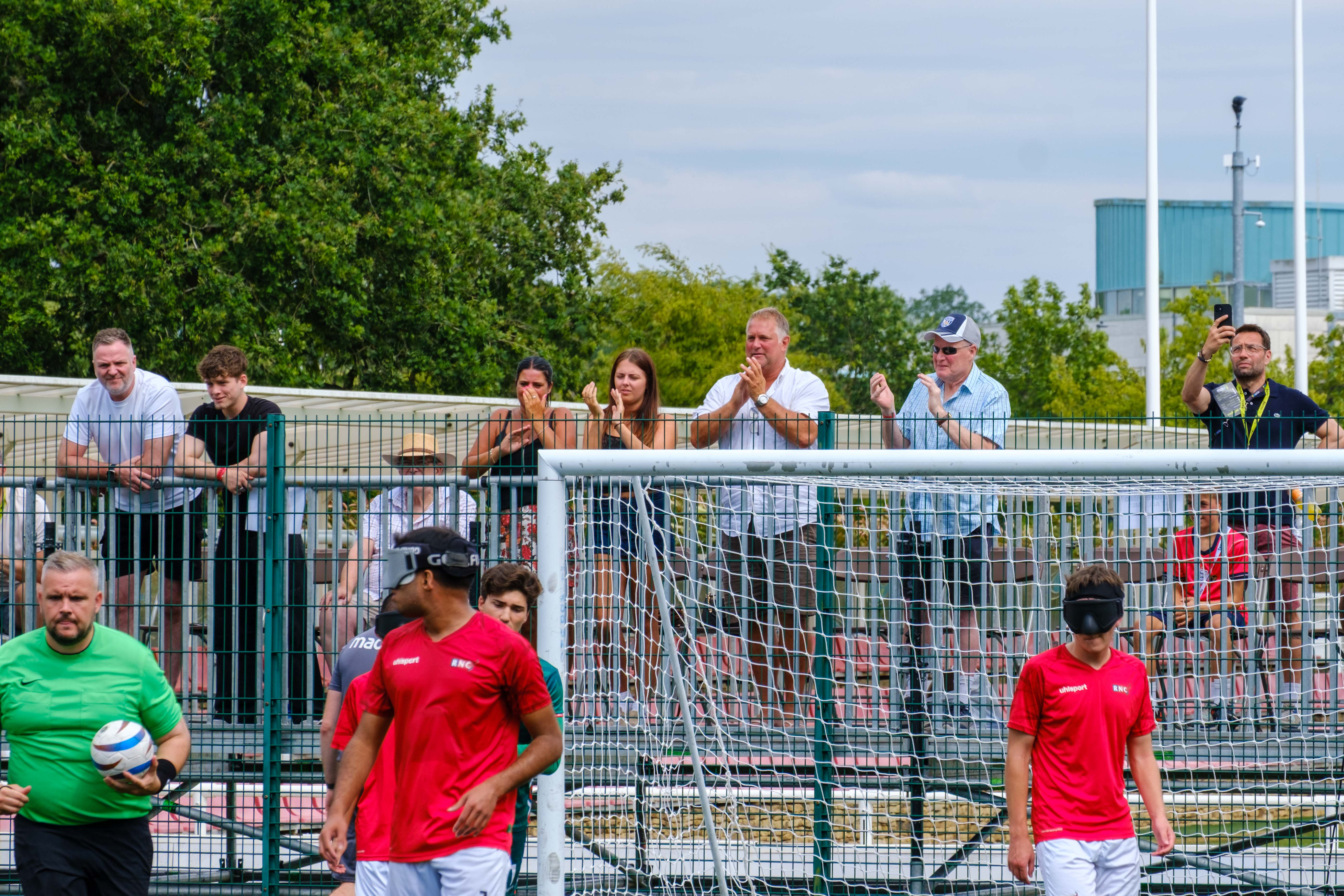 Spectators applauding a WBA goal, with the referee taking the ball to the centre circle.