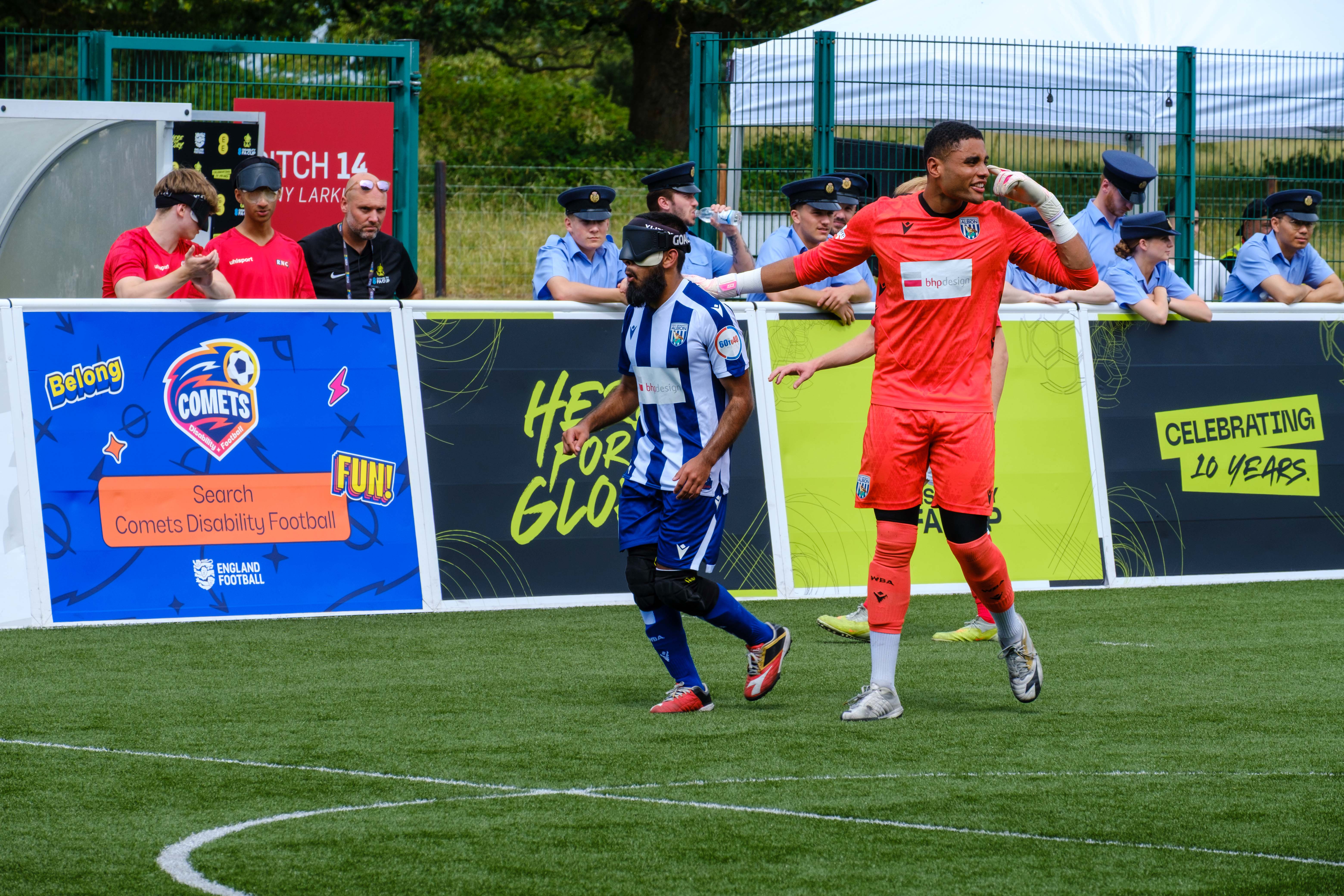 Owen Locke pointing at his head with a hand on Eesa shoulder as the set-up for the restart.
