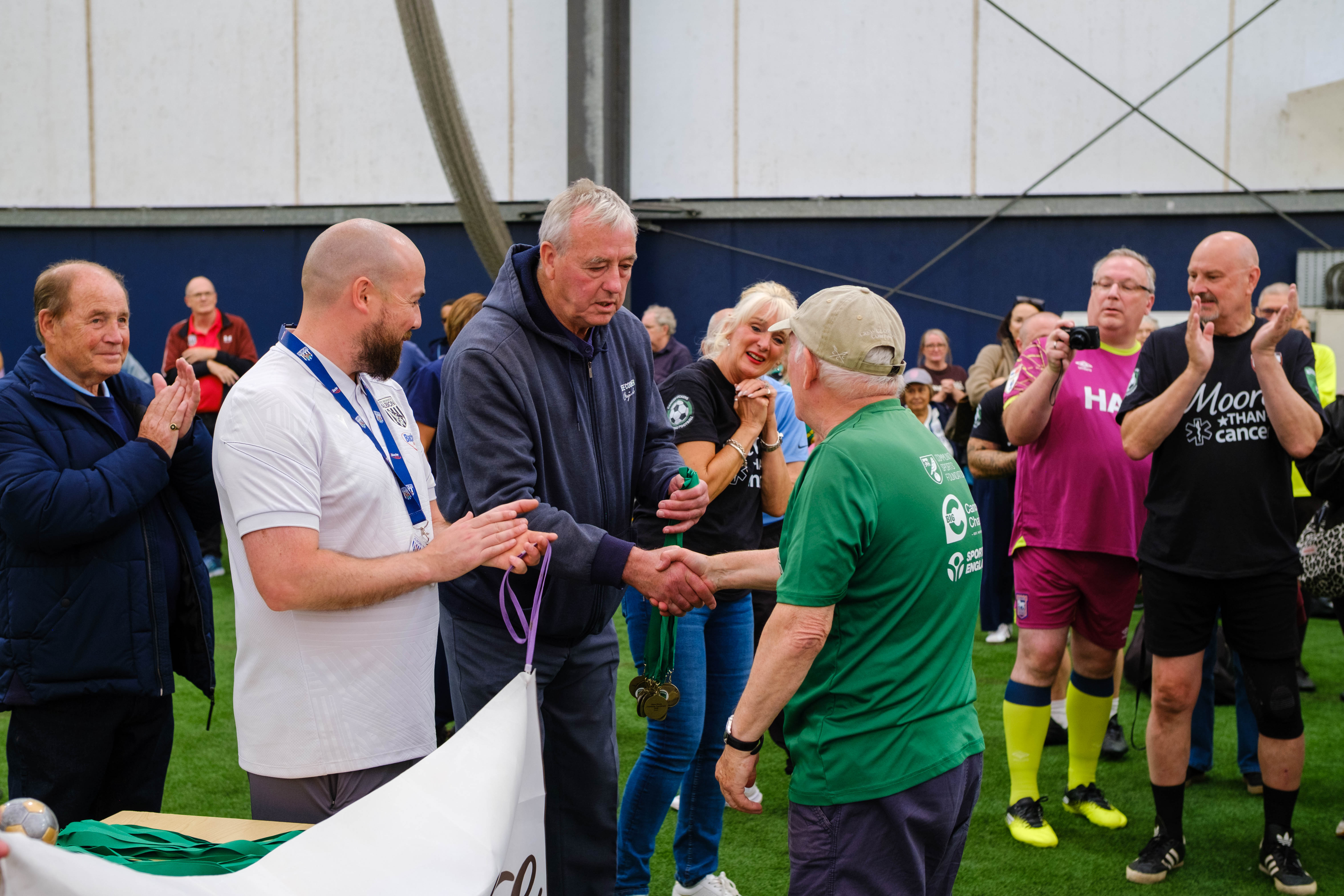 Joe Mayo handing medals to Big C's captain.