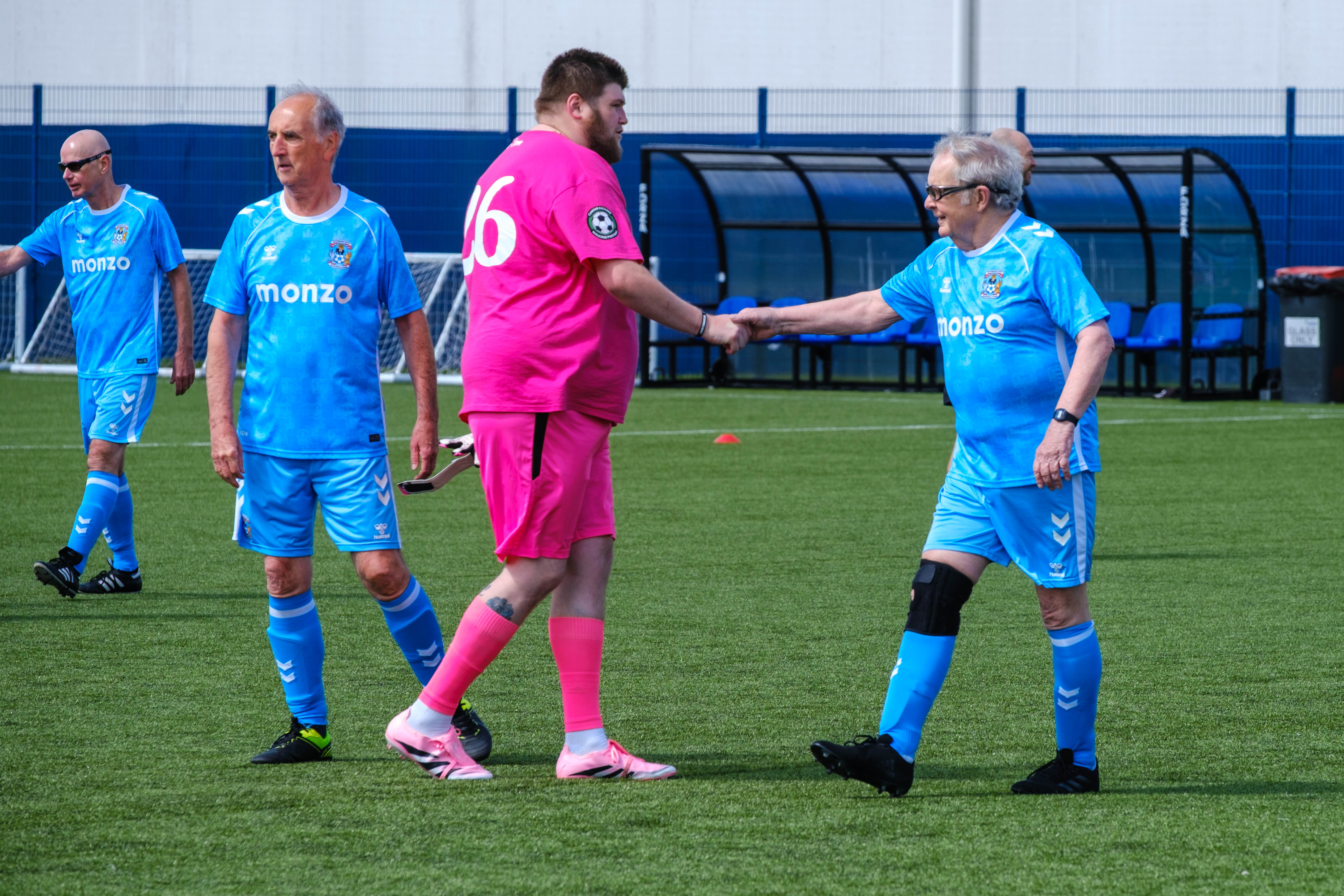 Sky Blue in the Community and Moore than Cancer players shaking hands after the game.