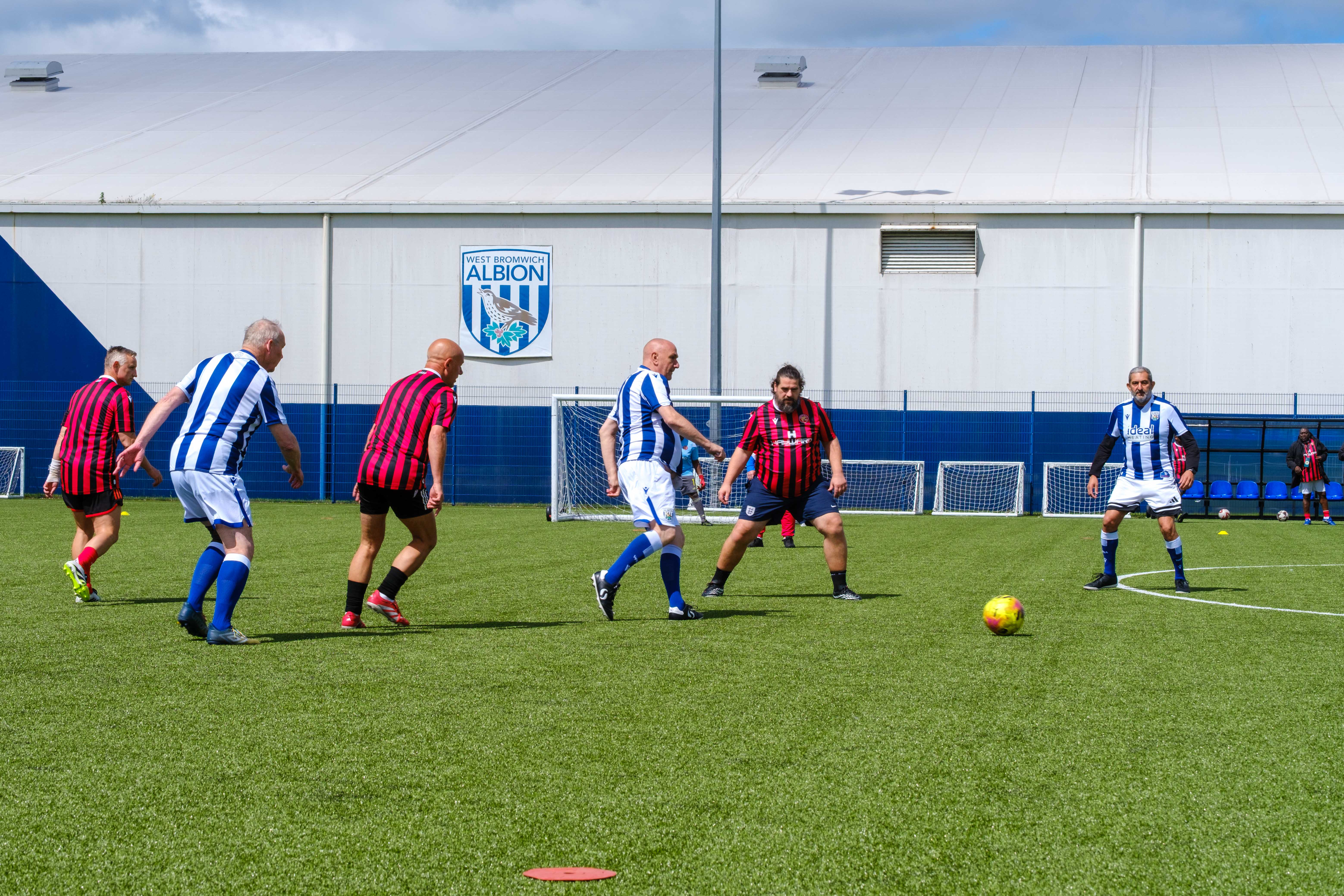 Wide shoot of Cancer Kickers and Beat the Block playing on the pitch.