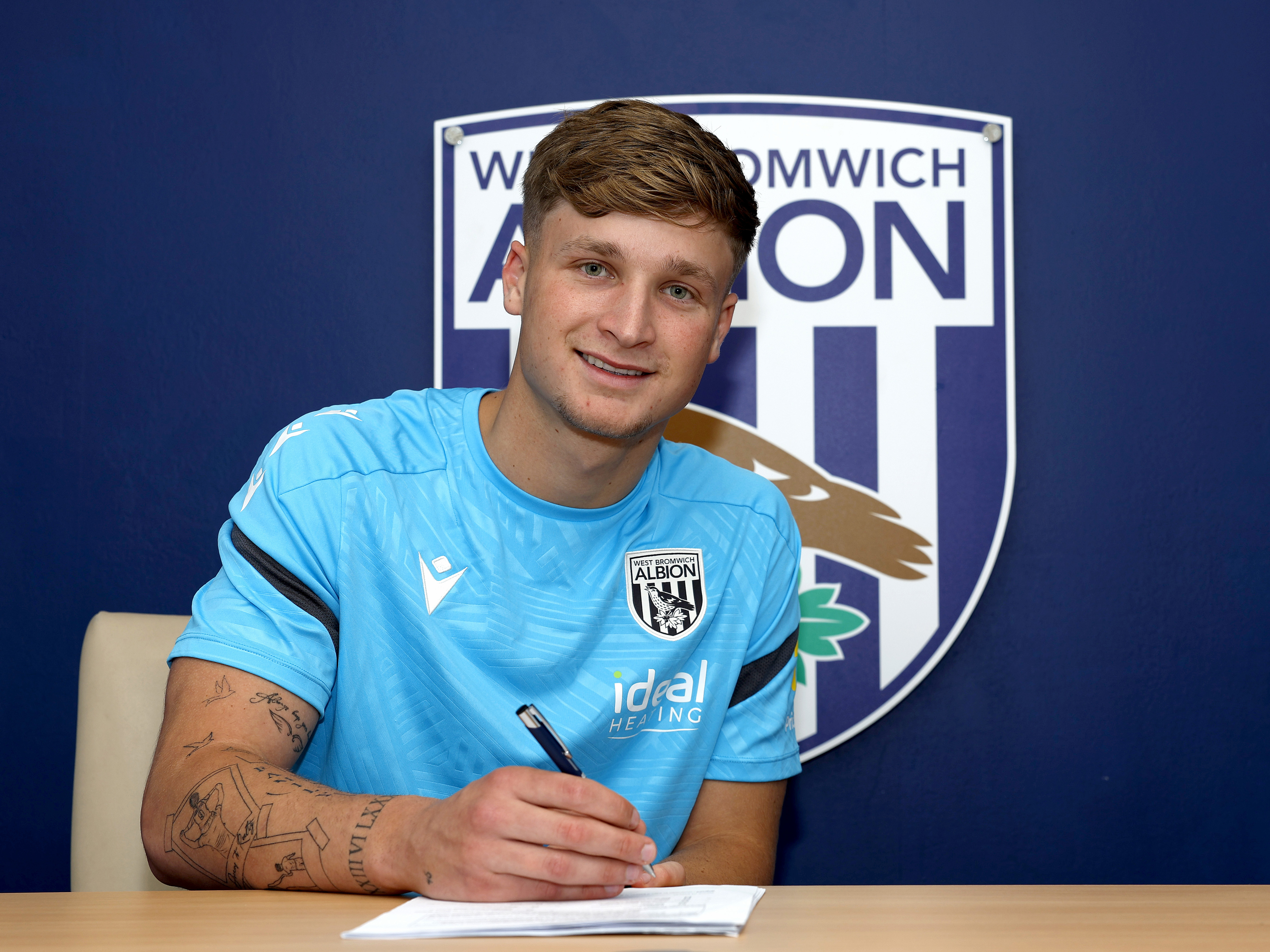 An image of JJ Morgan signing his contract