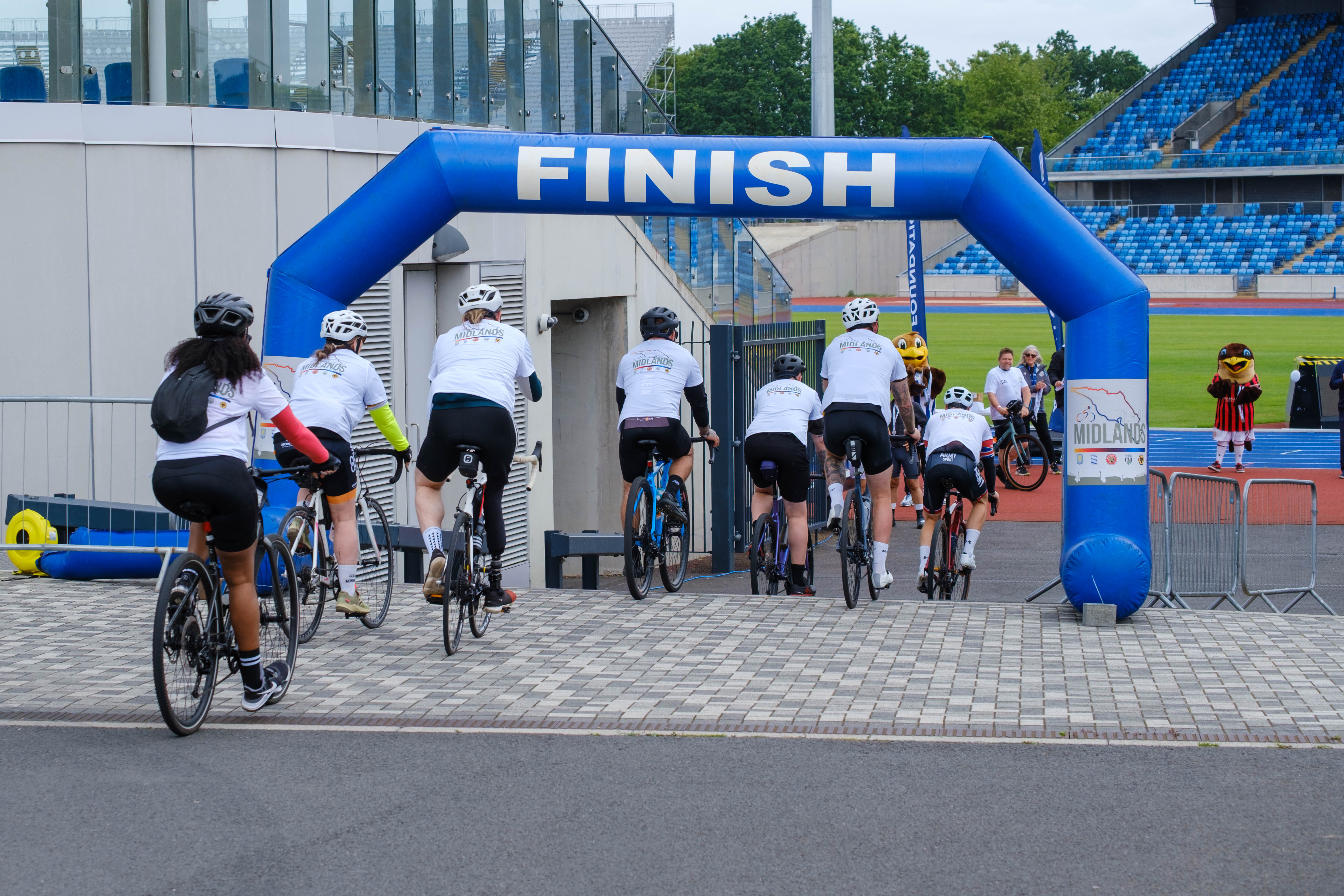 Cyclising cross the finishing line at Alexander Stadium.