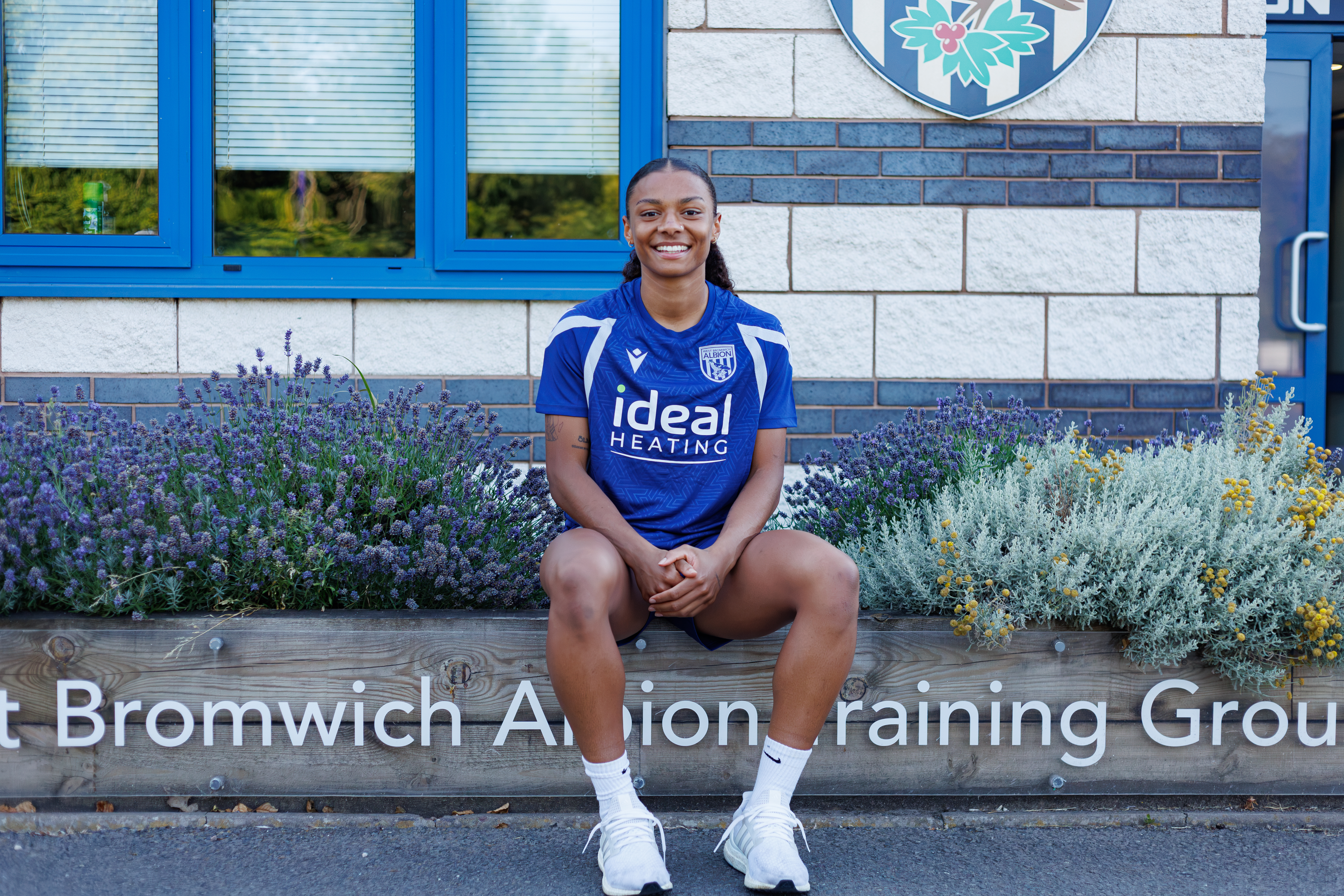 Izzy Lane sits outside the training ground