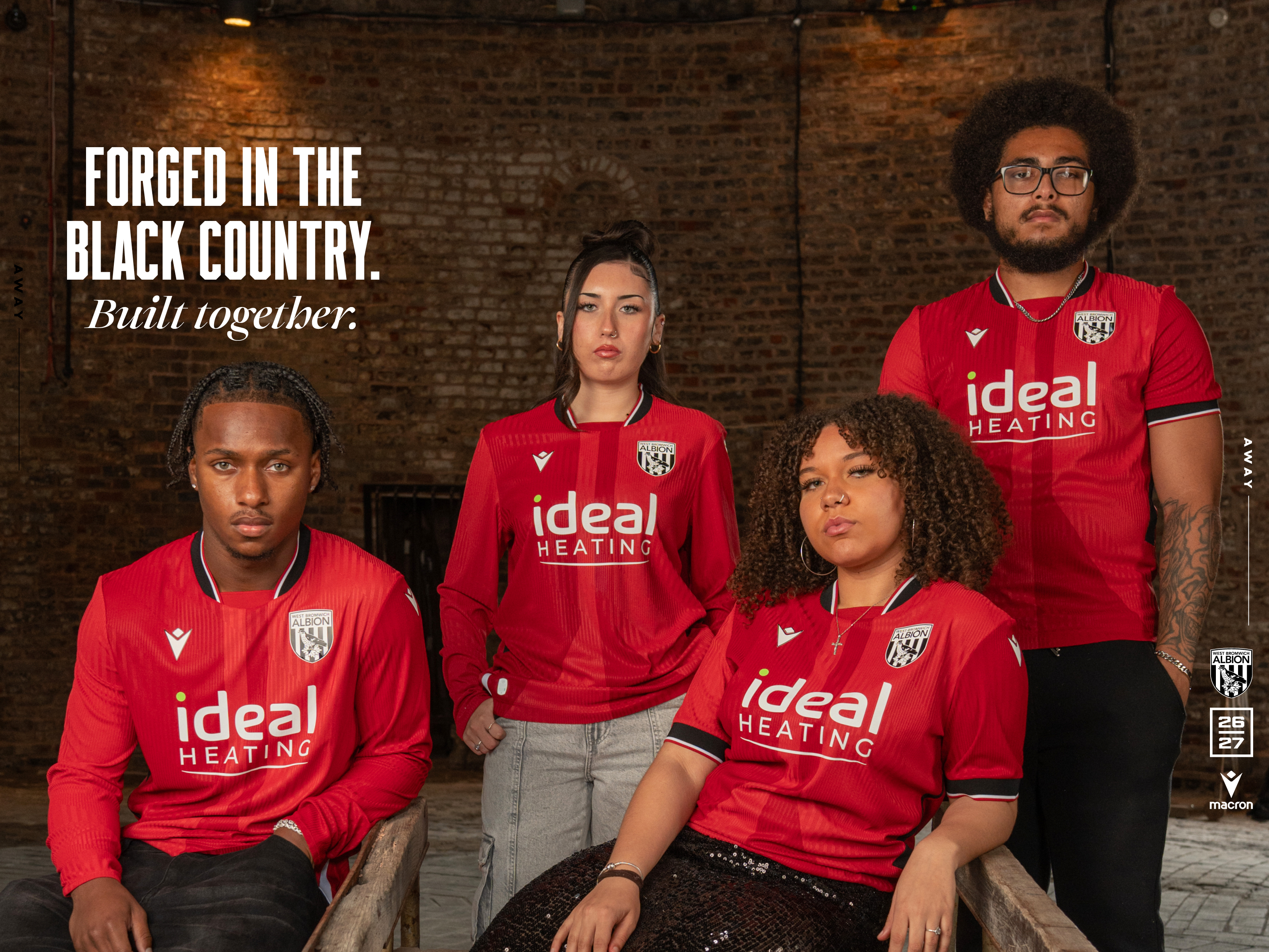 Four individuals posing for a photo in the new red away kit 