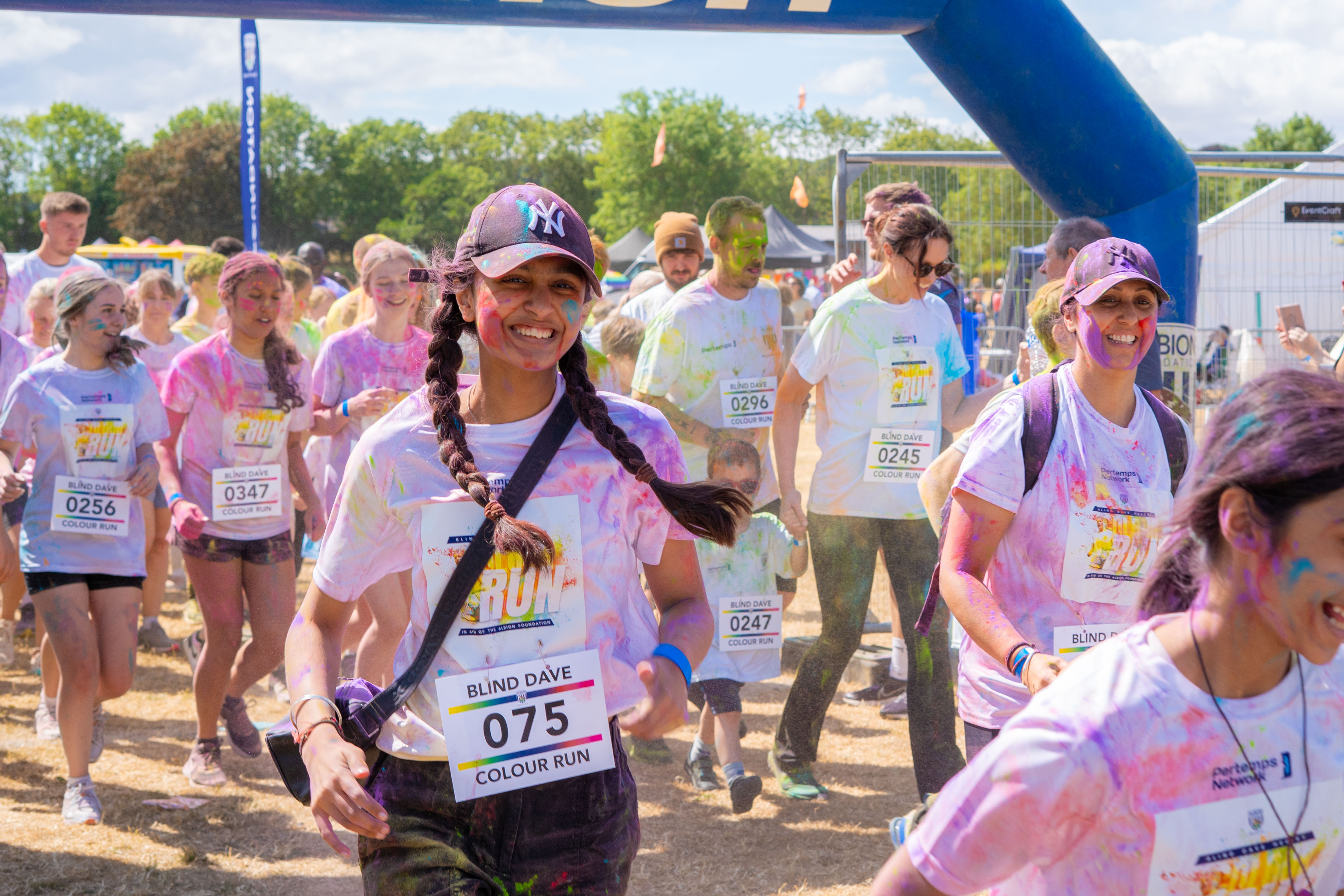 Participants smiling through the start line arch.