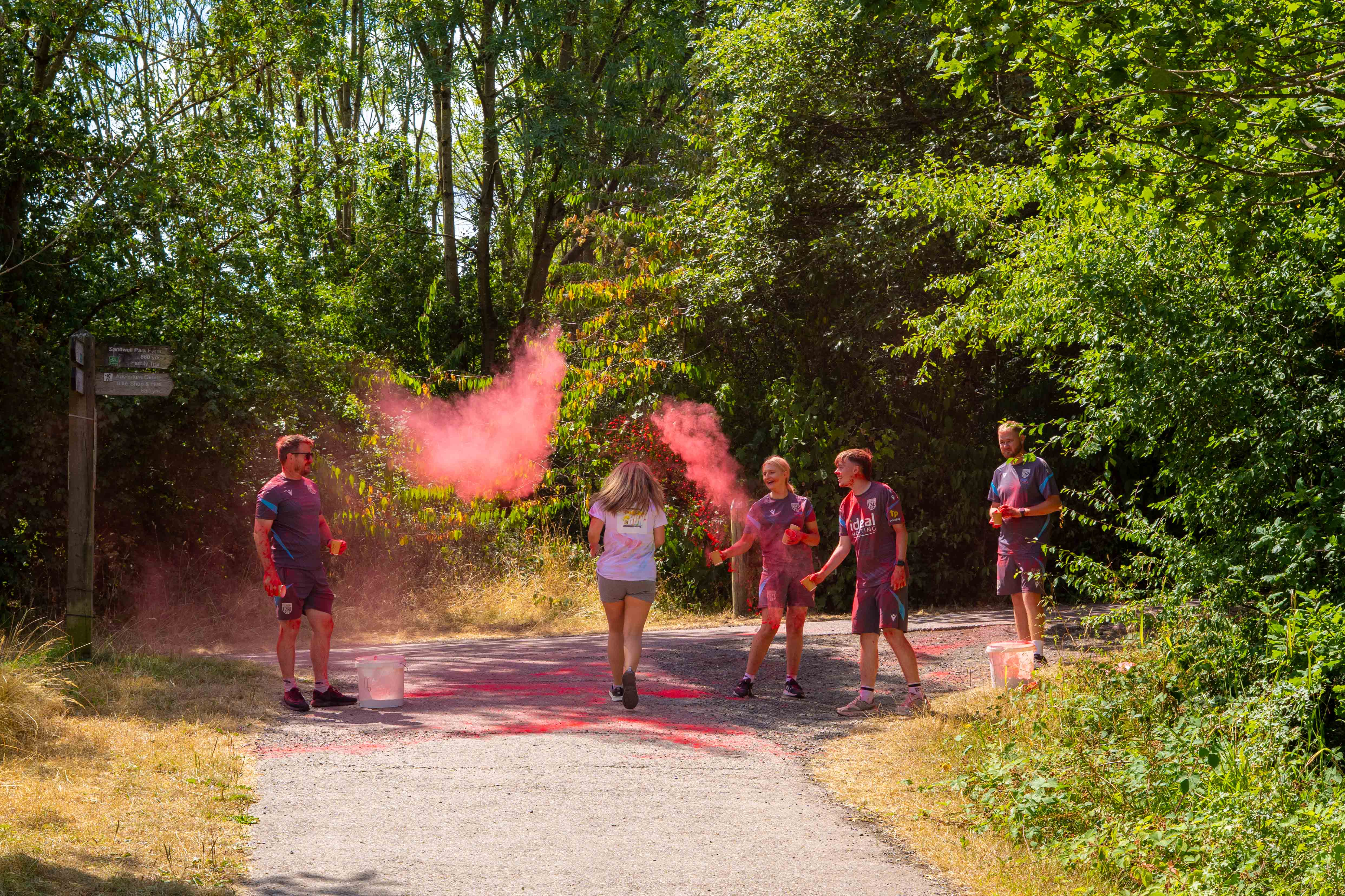 Participants move through a red powder station on the course.