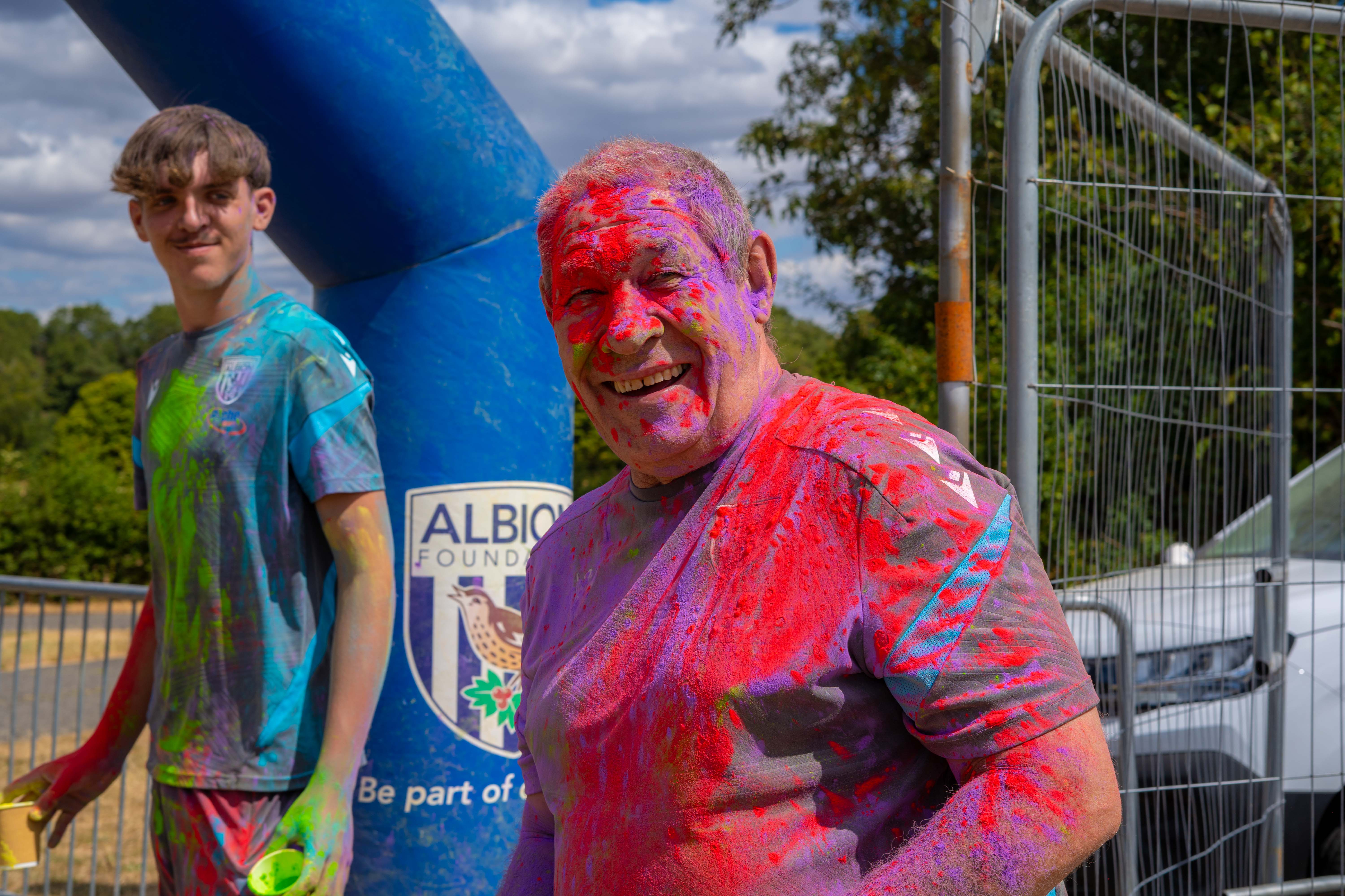 Foundation staff members covered in coloured powder posing for a portrait.
