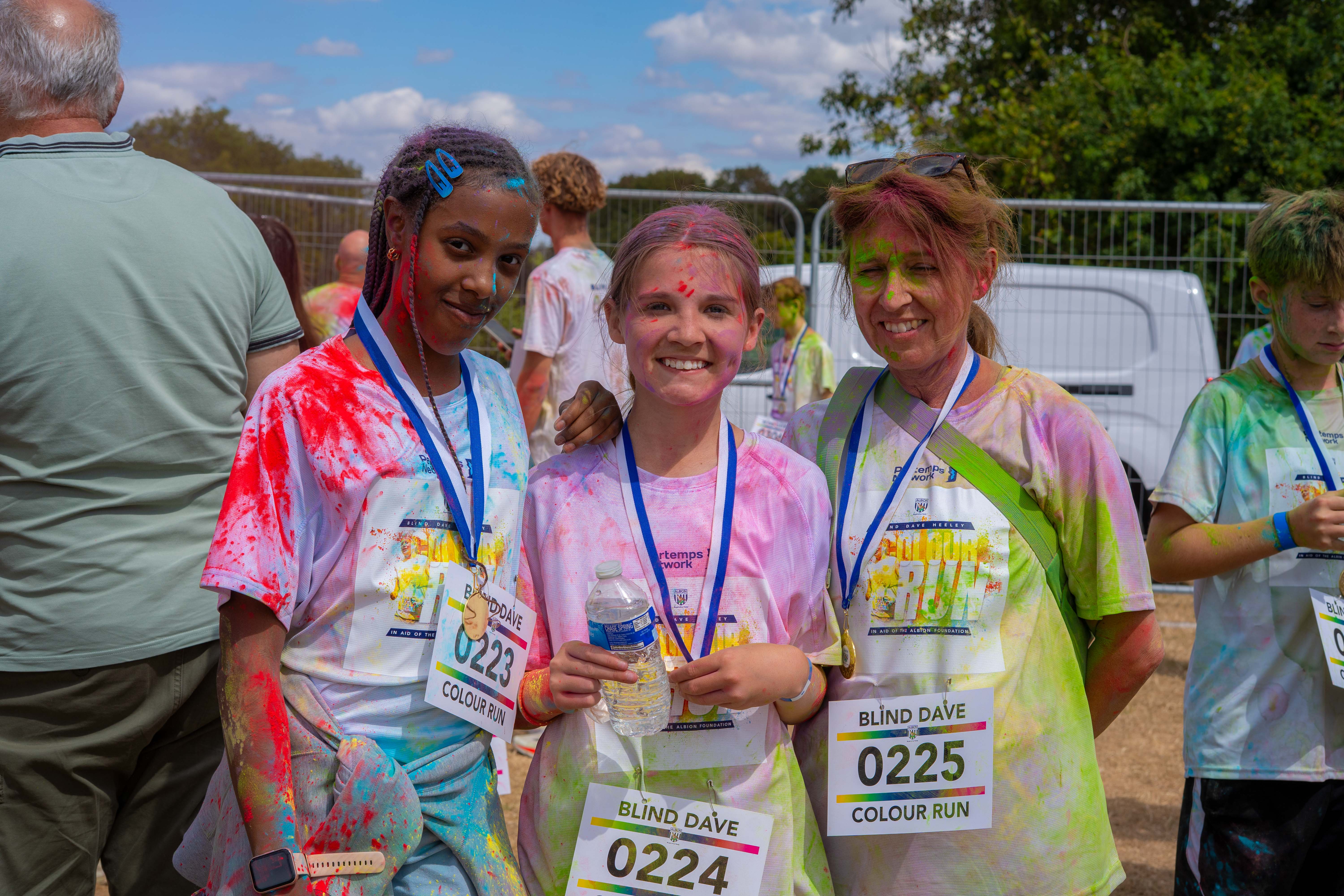 Three participants posing with finisher medals after the run.