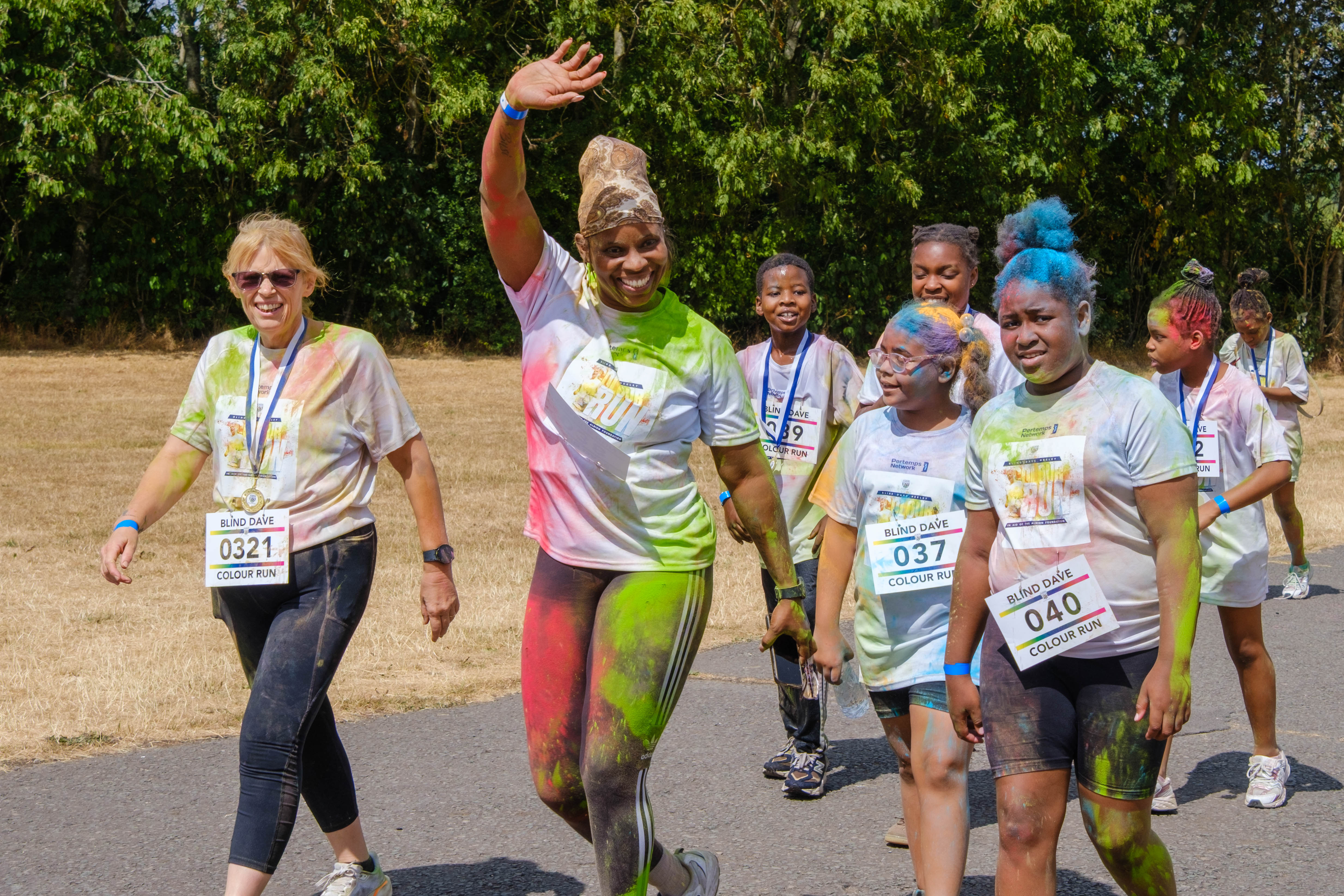 Group of participants approaching the finishing area waving.