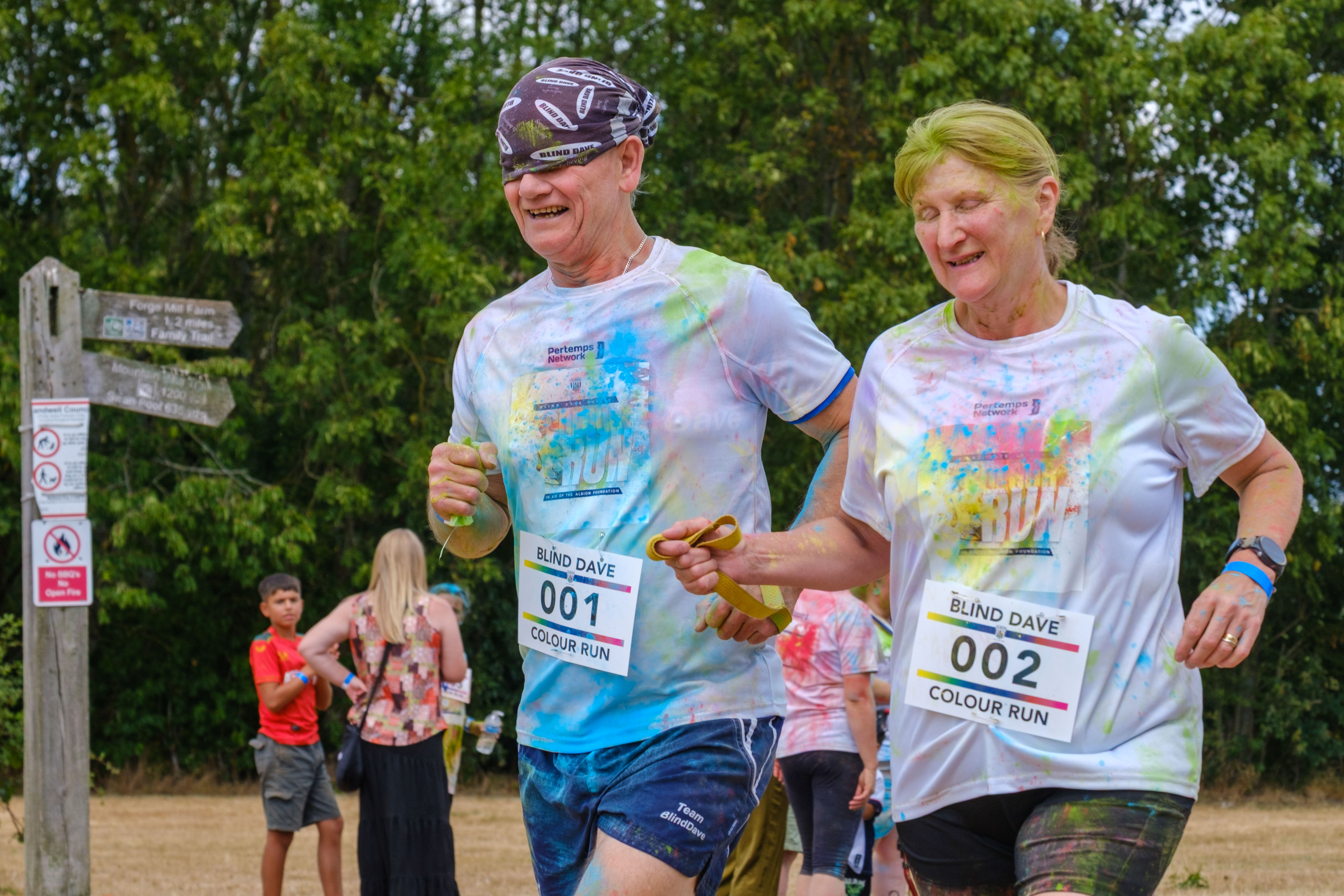 Blind Dave and guide running together towards the finish line.