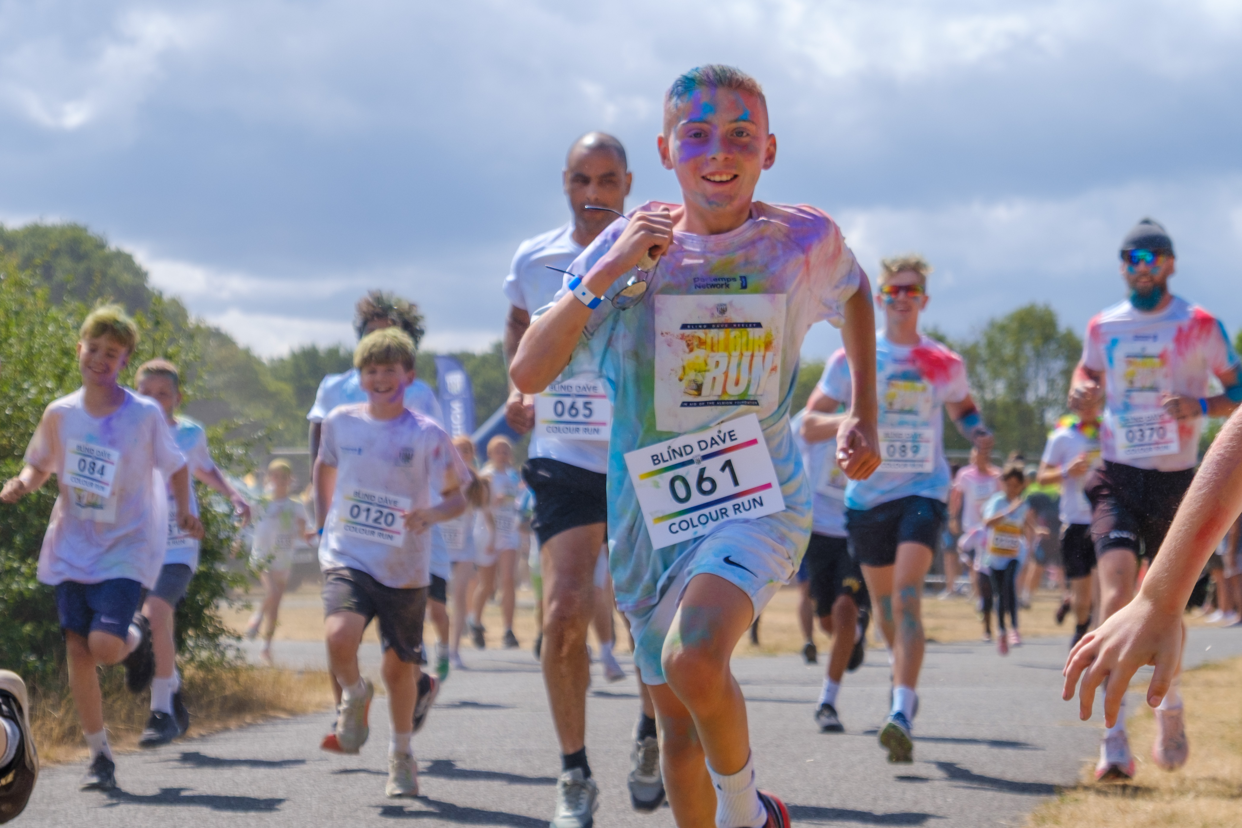 Participants run toward the camera during the color run event.