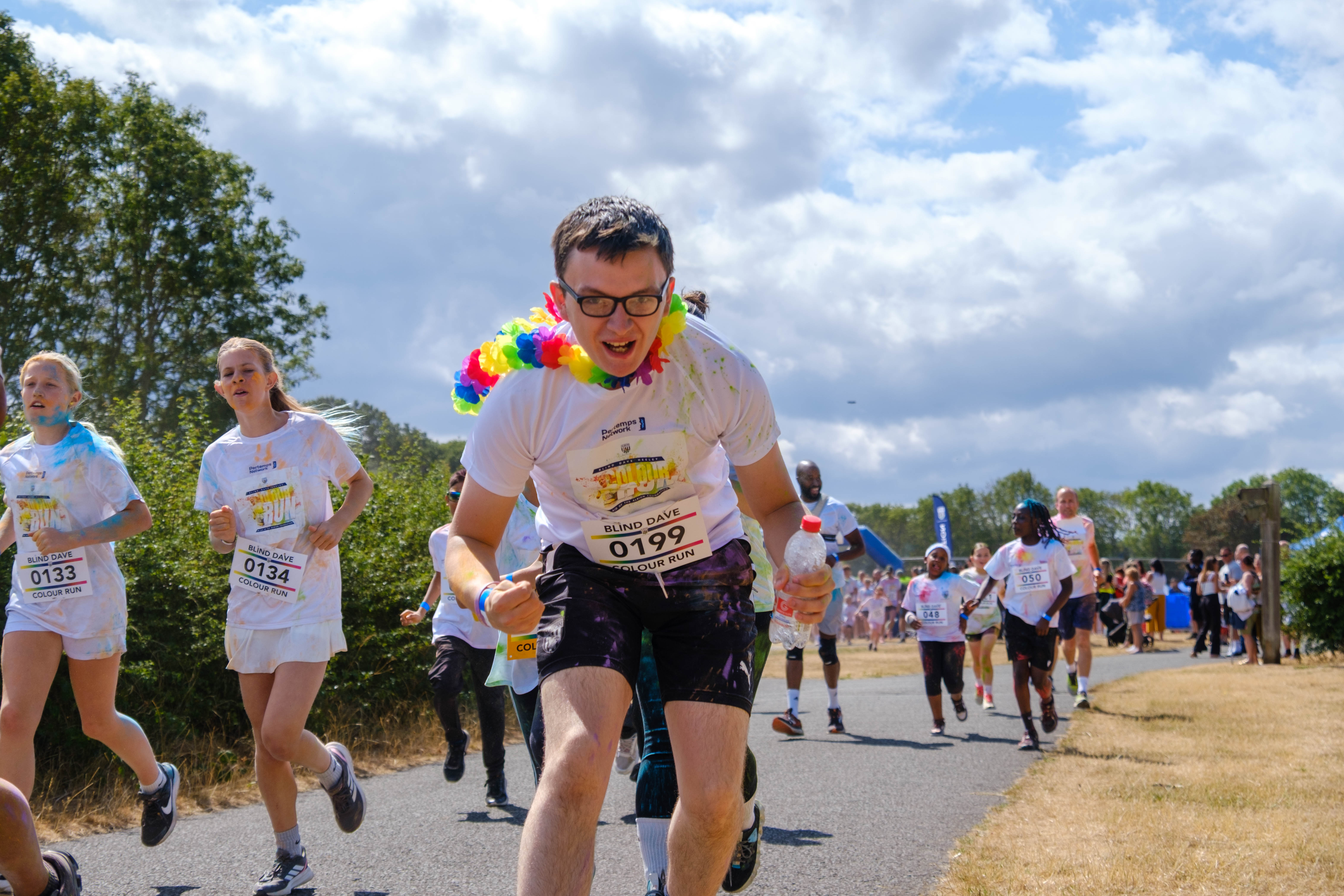 Participants cheering toward the camera during the color run event.
