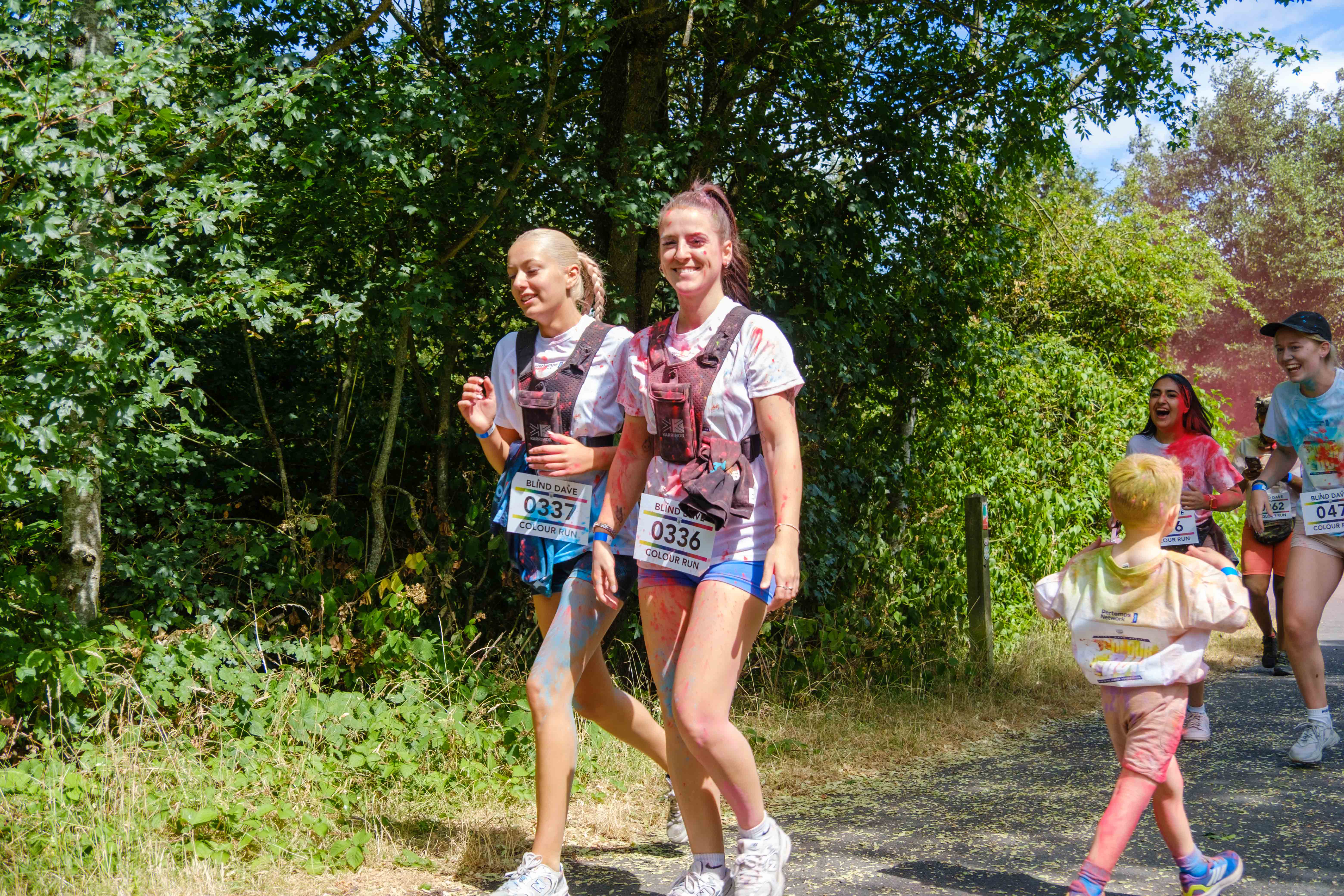 Two participants walk together along a wooded section of the course.